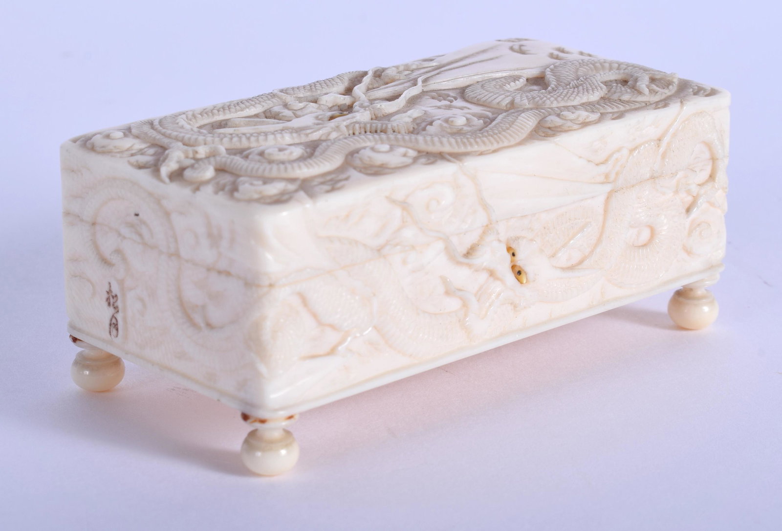 A 19TH CENTURY JAPANESE MEIJI PERIOD CARVED BONE BOX: A 19TH CENTURY JAPANESE MEIJI PERIOD CARVED BONE BOX decorated with Ryujin the dragon god of the sea. 7 cm x 3.75 cm.