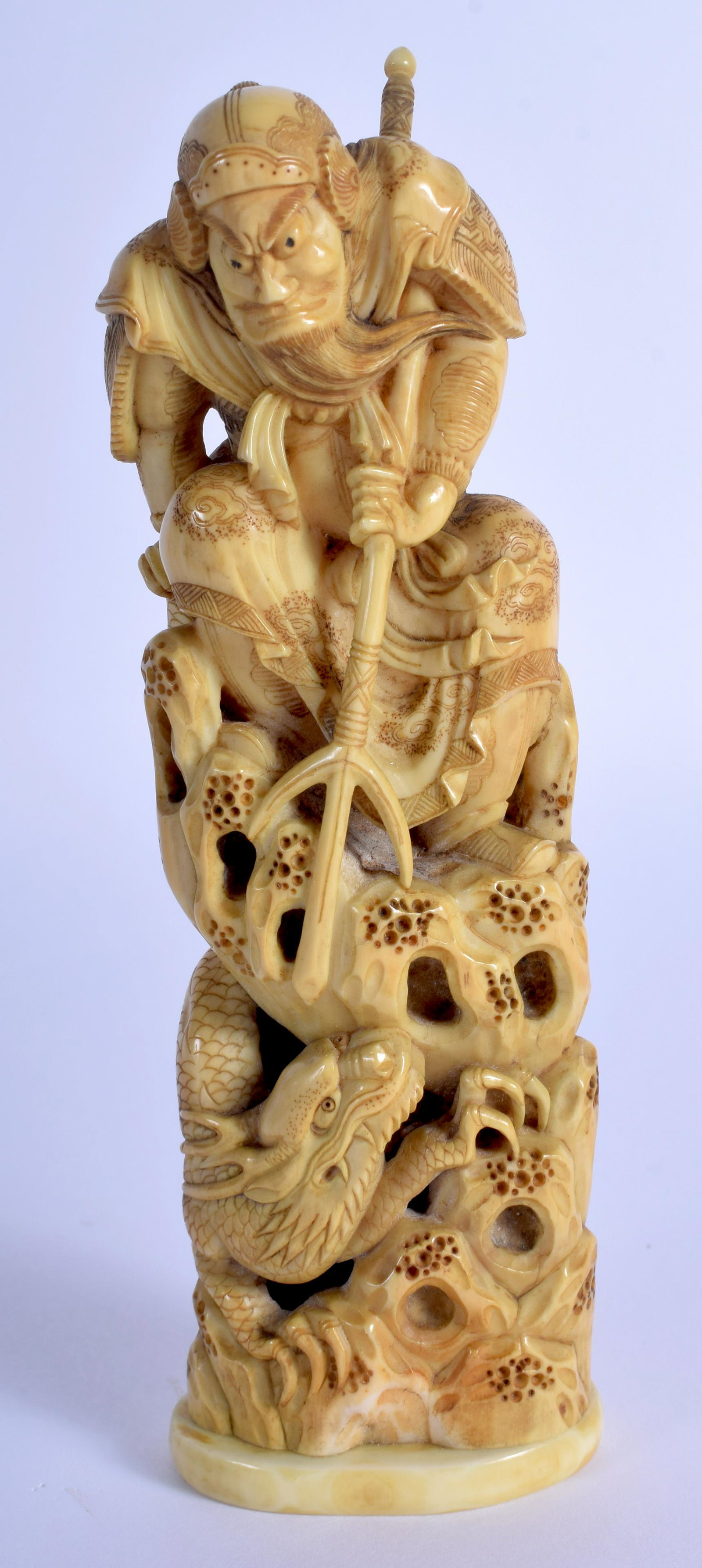 A 19TH CENTURY JAPANESE MEIJI PERIOD CARVED BONE: A 19TH CENTURY JAPANESE MEIJI PERIOD CARVED BONE OKIMONO modelled as Agatamori fighting Mizuchi the dragon. 13.5 cm high.