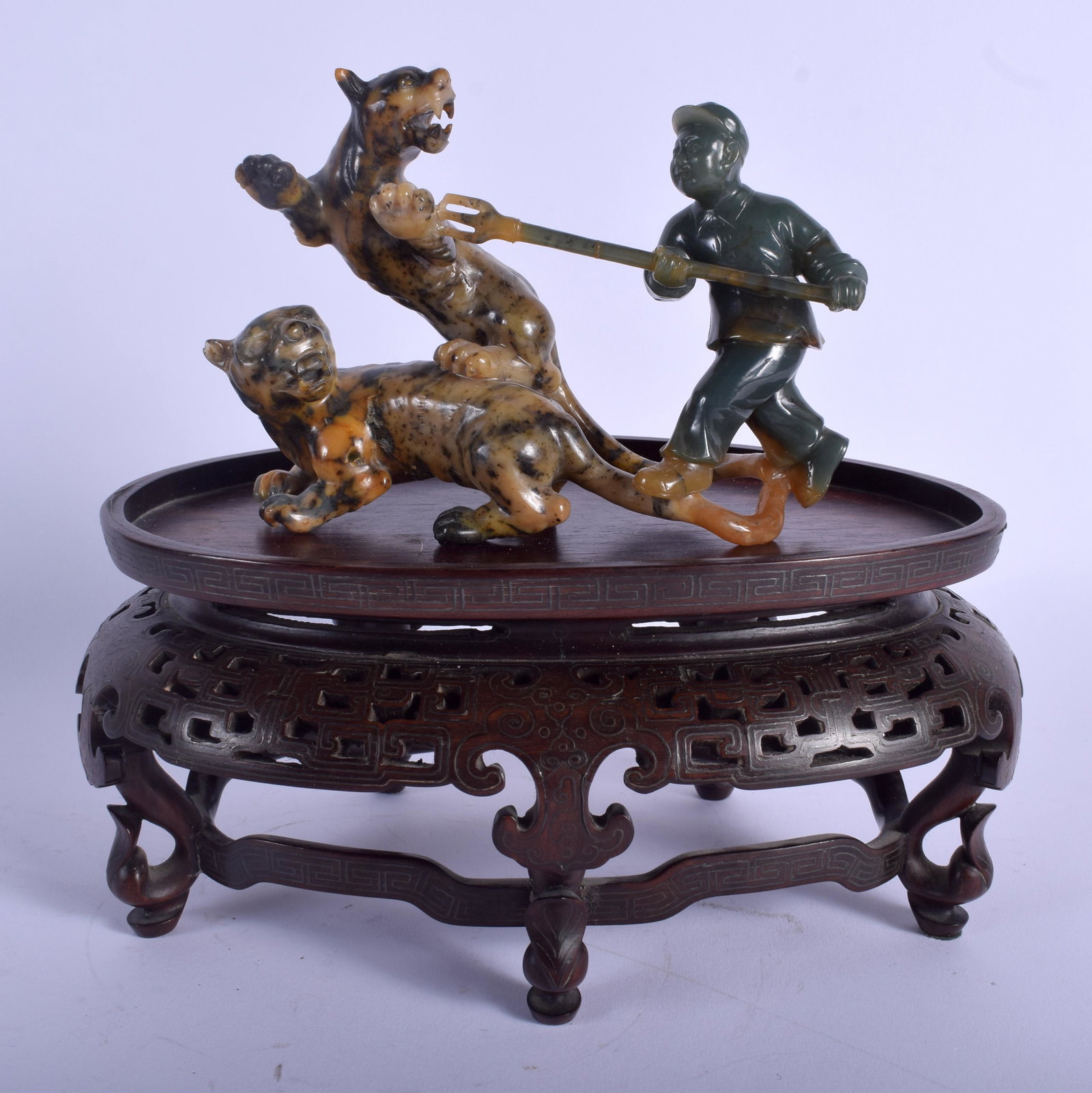 A LOVELY CHINESE CULTURAL REVOLUTION CARVED TWO TONE: A LOVELY CHINESE CULTURAL REVOLUTION CARVED TWO TONE JADEITE FIGURE modelled as a male holding back a rearing beast, upon a silver inlaid hongmu stand. Jadeite 14 cm x 12 cm.