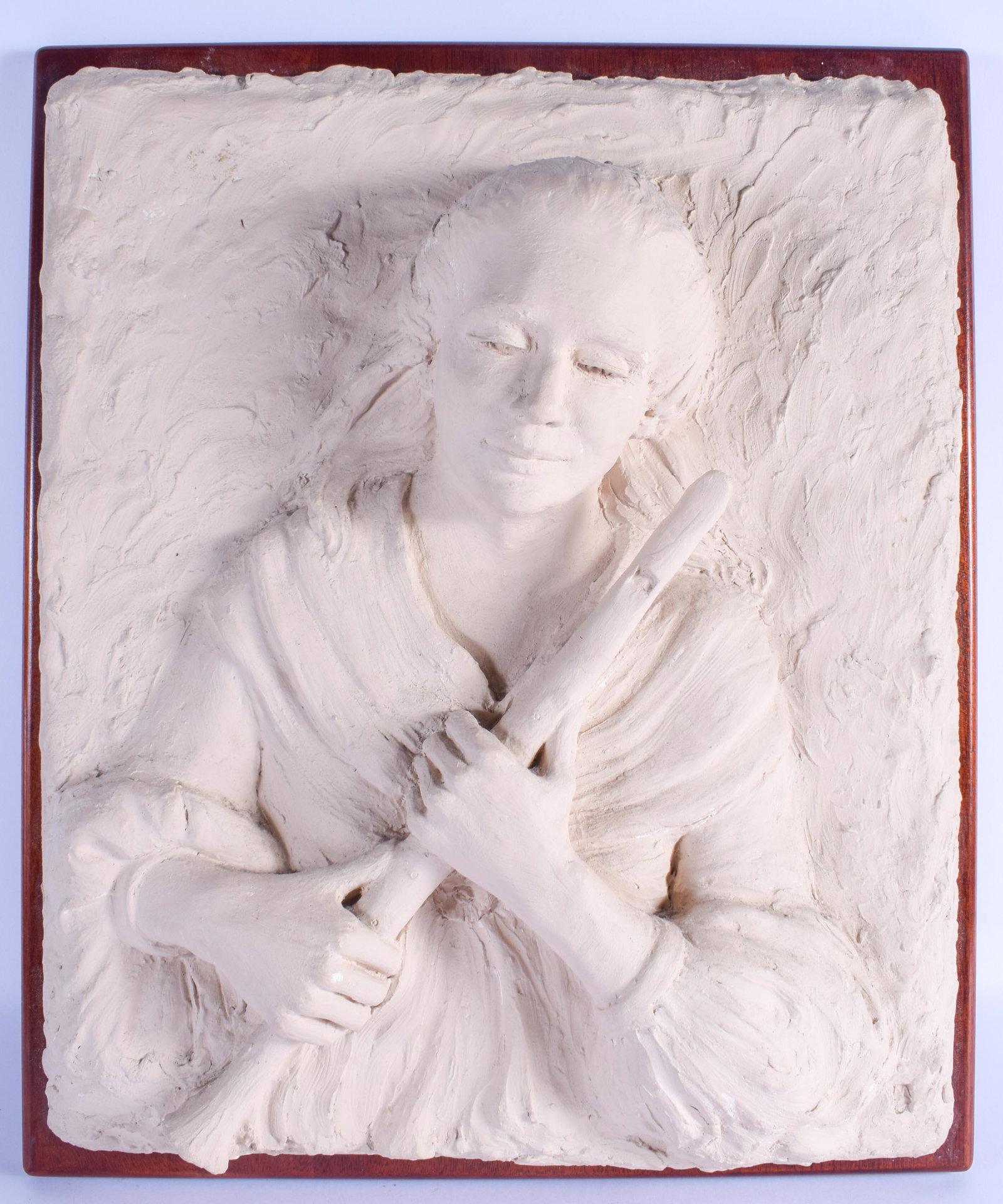 A LARGE MID 20TH CENTURY CARVED PLASTER POTTERY WALL: A LARGE MID 20TH CENTURY CARVED PLASTER POTTERY WALL PLAQUE modelled as a pipe player. 62 cm x 42 cm.