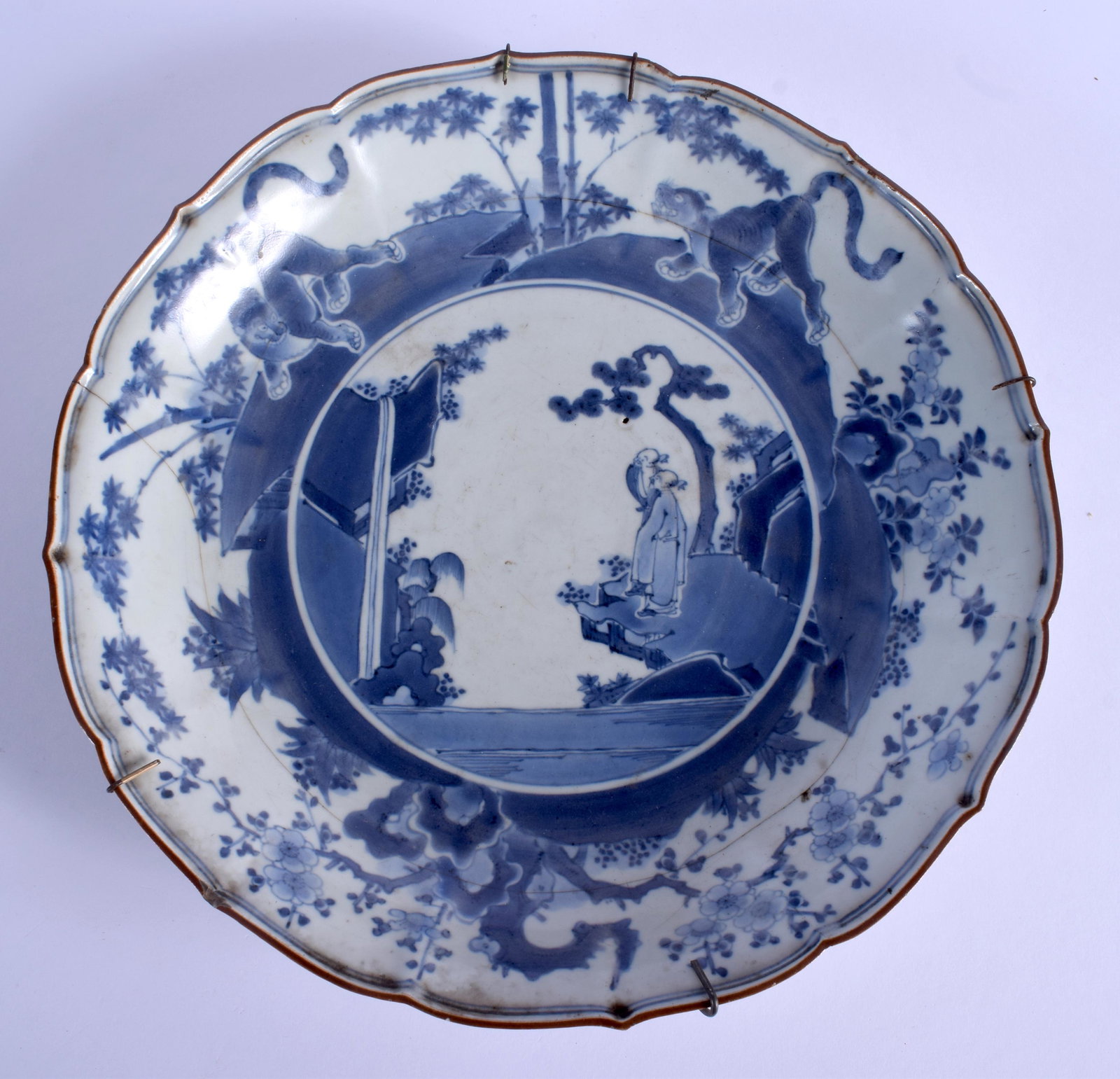 AN EARLY 18TH CENTURY JAPANESE EDO PERIOD BLUE AND: AN EARLY 18TH CENTURY JAPANESE EDO PERIOD BLUE AND WHITE SCALLOPED DISH painted with immortals. 30 cm diameter.