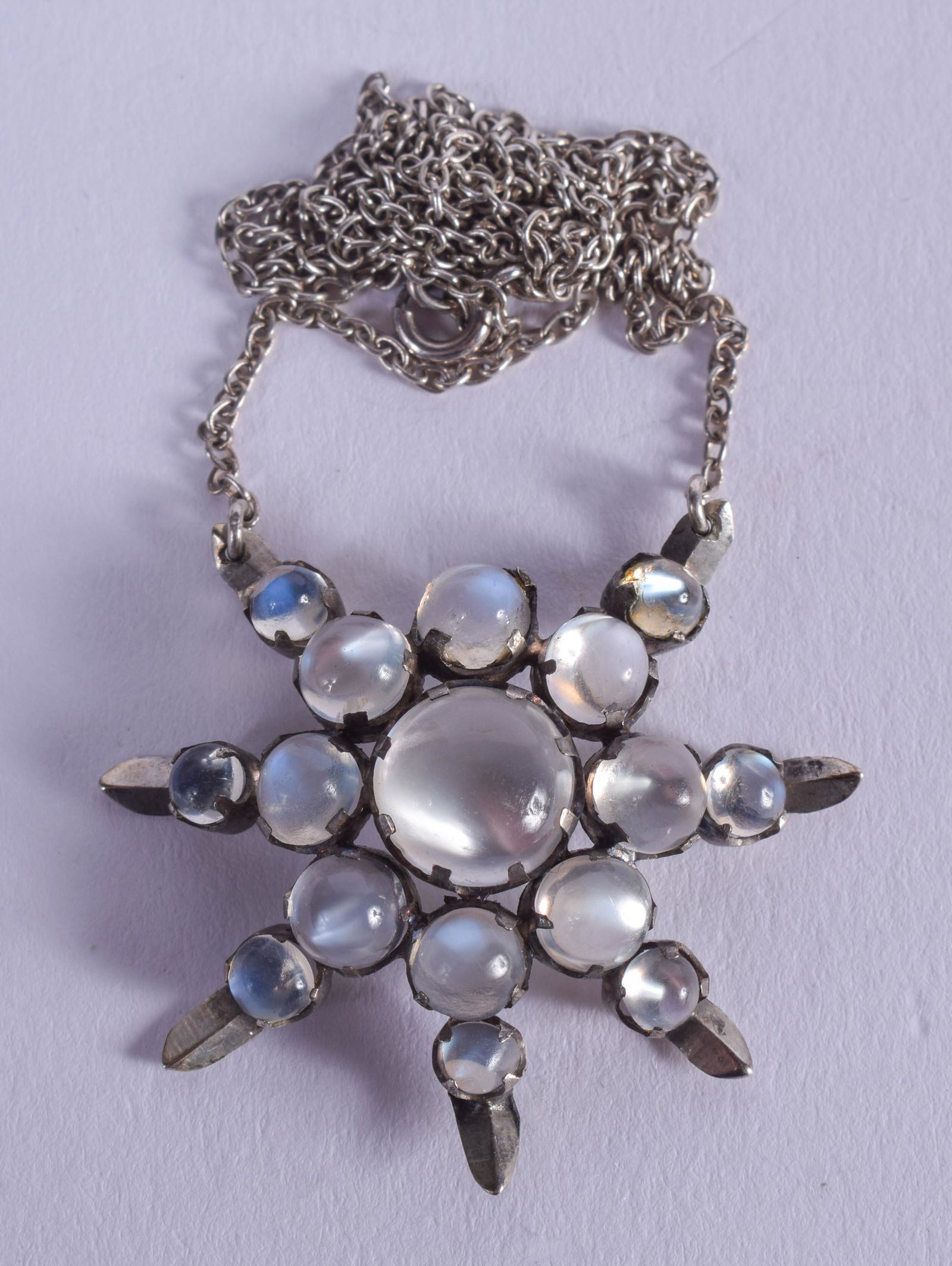 A SILVER AND MOONSTONE NECKLACE. 5 grams. Pendant 2.75: A SILVER AND MOONSTONE NECKLACE. 5 grams. Pendant 2.75 cm x 2.75 cm.