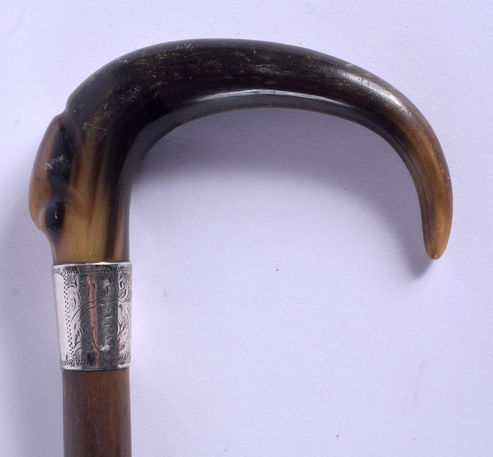 A 19TH CENTURY CONTINENTAL CARVED BUFFALO HORN WALKING: A 19TH CENTURY CONTINENTAL CARVED BUFFALO HORN WALKING CANE with silver mounts. 88 cm long.