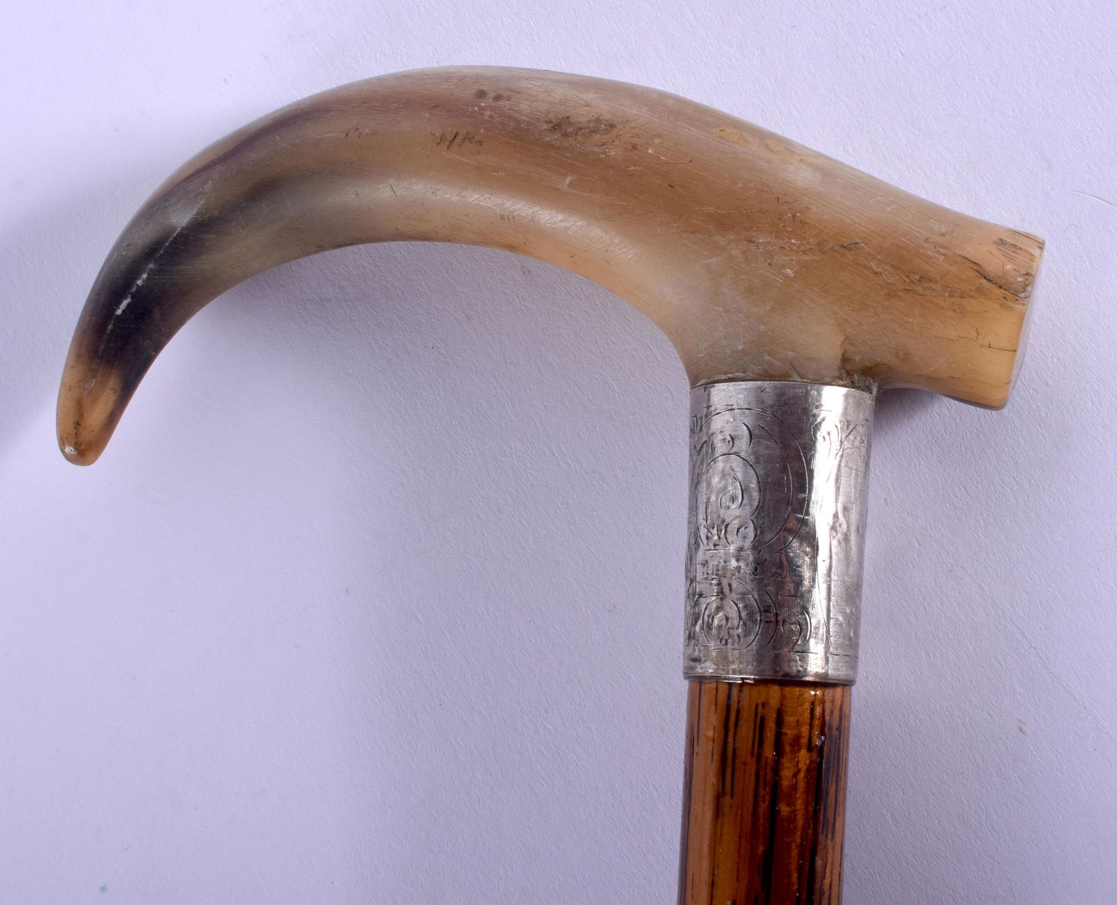 A 19TH CENTURY CONTINENTAL CARVED BUFFALO HORN WALKING: A 19TH CENTURY CONTINENTAL CARVED BUFFALO HORN WALKING CANE with silver mounts. 88 cm long.