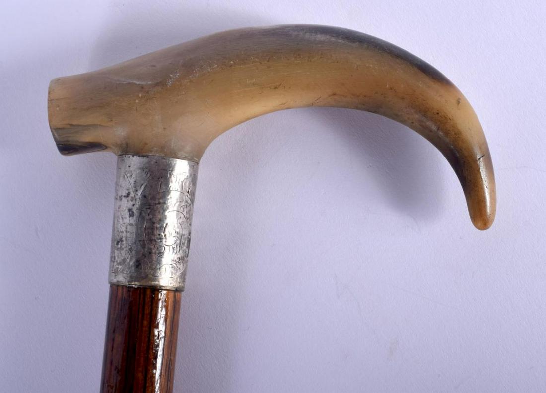 A 19TH CENTURY CONTINENTAL CARVED BUFFALO HORN WALKING: A 19TH CENTURY CONTINENTAL CARVED BUFFALO HORN WALKING CANE with silver mounts. 88 cm long.