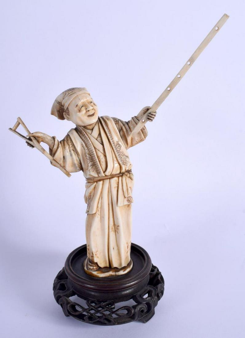 A 19TH CENTURY JAPANESE MEIJI PERIOD CARVED BONE: A 19TH CENTURY JAPANESE MEIJI PERIOD CARVED BONE OKIMONO modelled holding a long stick. Bone 16.5 cm high.