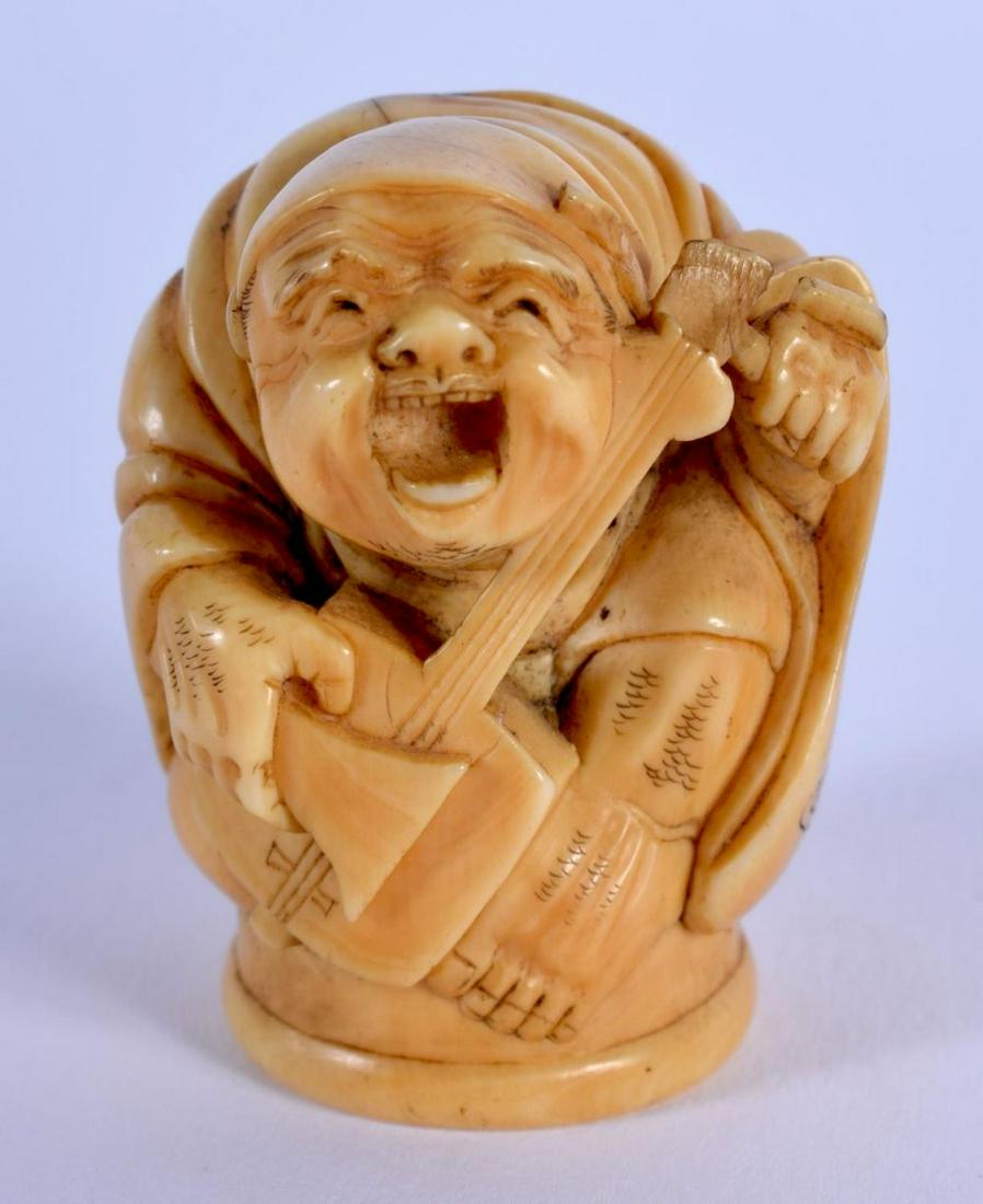 A 19TH CENTURY JAPANESE MEIJI PERIOD CARVED BONE: A 19TH CENTURY JAPANESE MEIJI PERIOD CARVED BONE OKIMONO modelled as a musician. 3.5 cm x 2.75 cm.