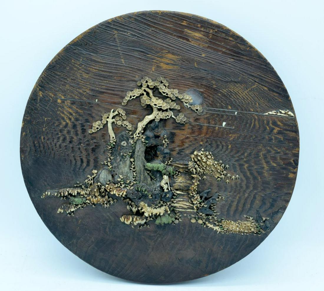 A LARGE 19TH CENTURY JAPANESE MEIJI PERIOD CARVED AND: A LARGE 19TH CENTURY JAPANESE MEIJI PERIOD CARVED AND STAINED ANTLER AND BONE PLAQUE depicting a roaming male within a landscape. 37 cm diameter.