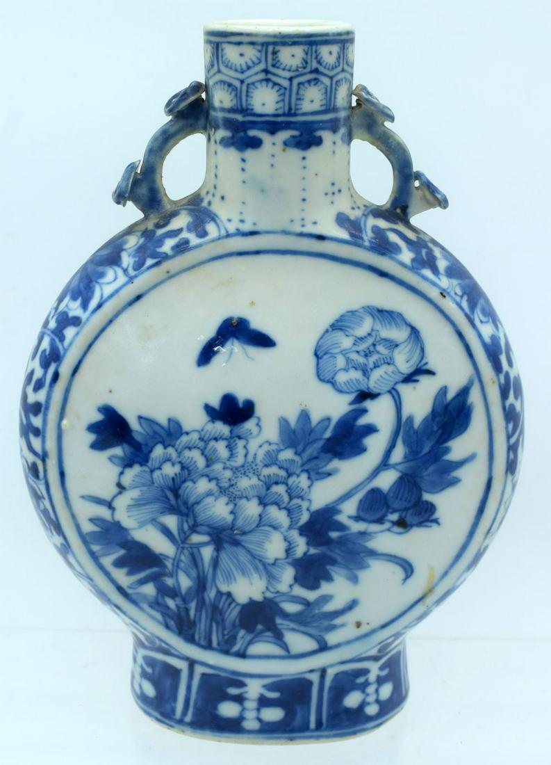 A 19TH CENTURY CHINESE BLUE AND WHITE PORCELAIN PILGRIM: A 19TH CENTURY CHINESE BLUE AND WHITE PORCELAIN PILGRIM FLASK bearing Kangxi marks to base, painted with flowers. 20 cm x 14 cm.