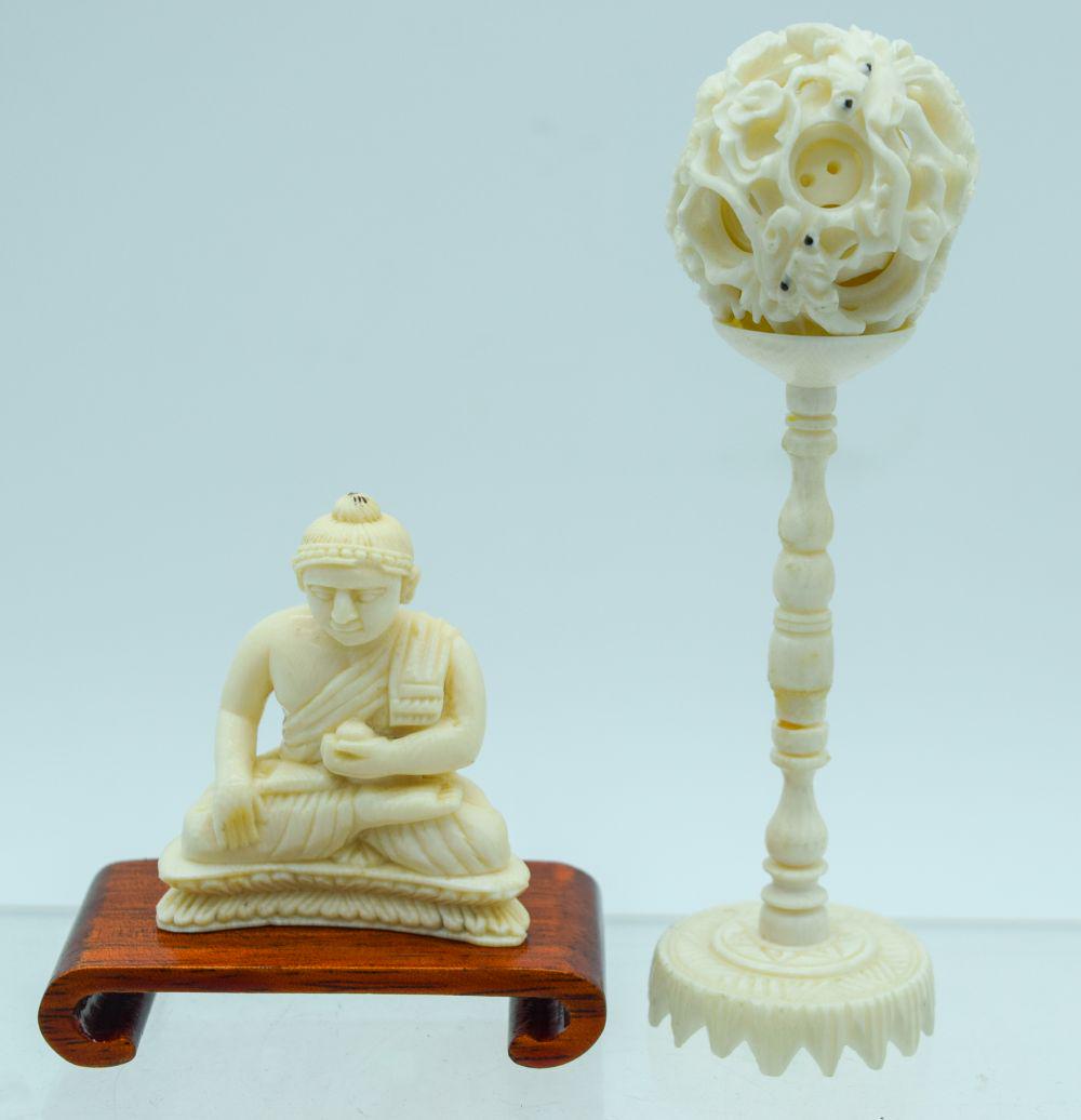 AN EARLY 20TH CENTURY CARVED BONE PUZZLE BALL ON STAND: AN EARLY 20TH CENTURY CARVED BONE PUZZLE BALL ON STAND Late Qing/Republic, together with an antique bone buddha. Largest 12 cm high. (2)
