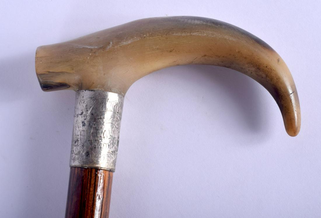 A 19TH CENTURY CONTINENTAL CARVED BUFFALO HORN WALKING: A 19TH CENTURY CONTINENTAL CARVED BUFFALO HORN WALKING CANE with silver mounts. 88 cm long.