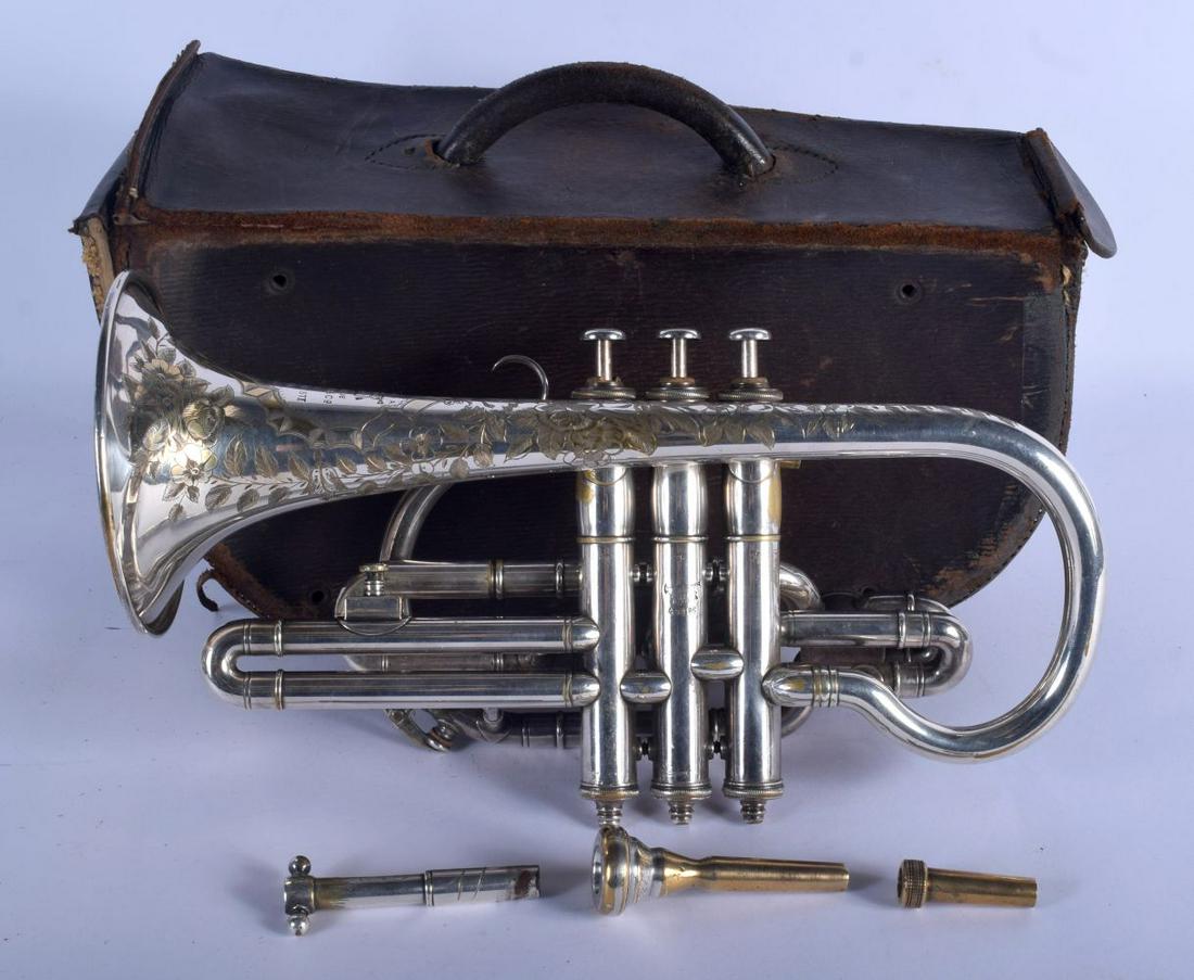 A BOXED BOOSEY & CO TRUMPET decorated with foliage. 33: A BOXED BOOSEY & CO TRUMPET decorated with foliage. 33 cm wide.