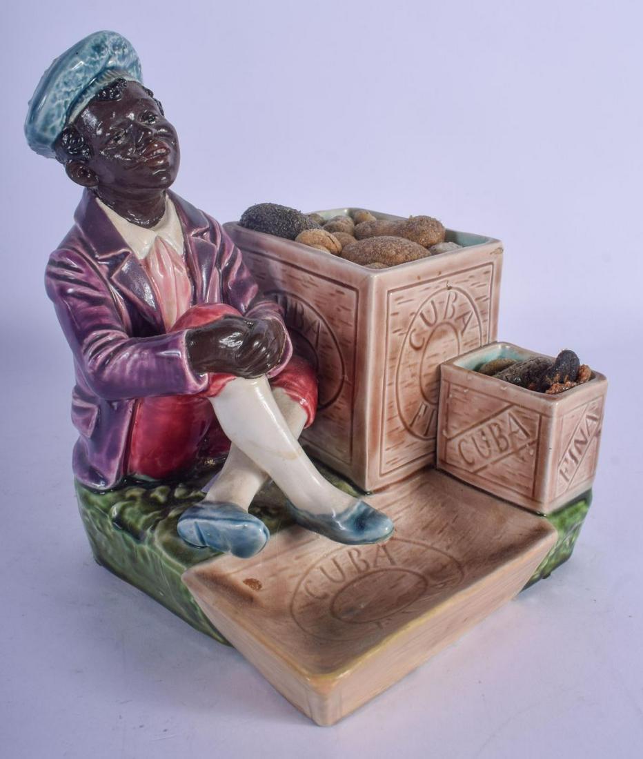AN UNUSUAL EUROPEAN PAINTED POTTERY FIGURE OF A CUBAN: AN UNUSUAL EUROPEAN PAINTED POTTERY FIGURE OF A CUBAN modelled beside 2 crates of fruit. 15 cm x 12 cm.