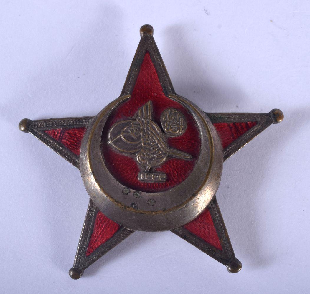 AN UNUSUAL MIDDLE EASTERN BRASS AND ENAMEL STAR BADGE. (1 of 2)