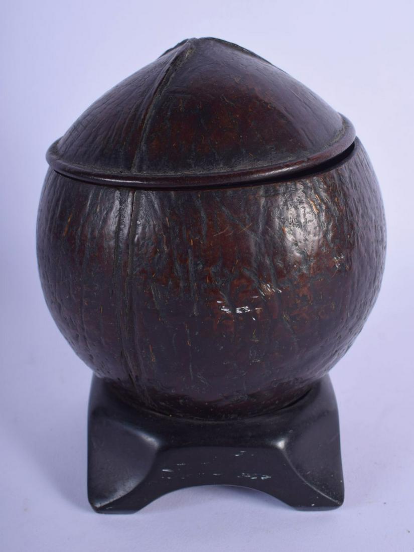 A GEORGE III CARVED COCONUT TEA CADDY upon a hardwood: A GEORGE III CARVED COCONUT TEA CADDY upon a hardwood base. 16 cm x 8 cm.