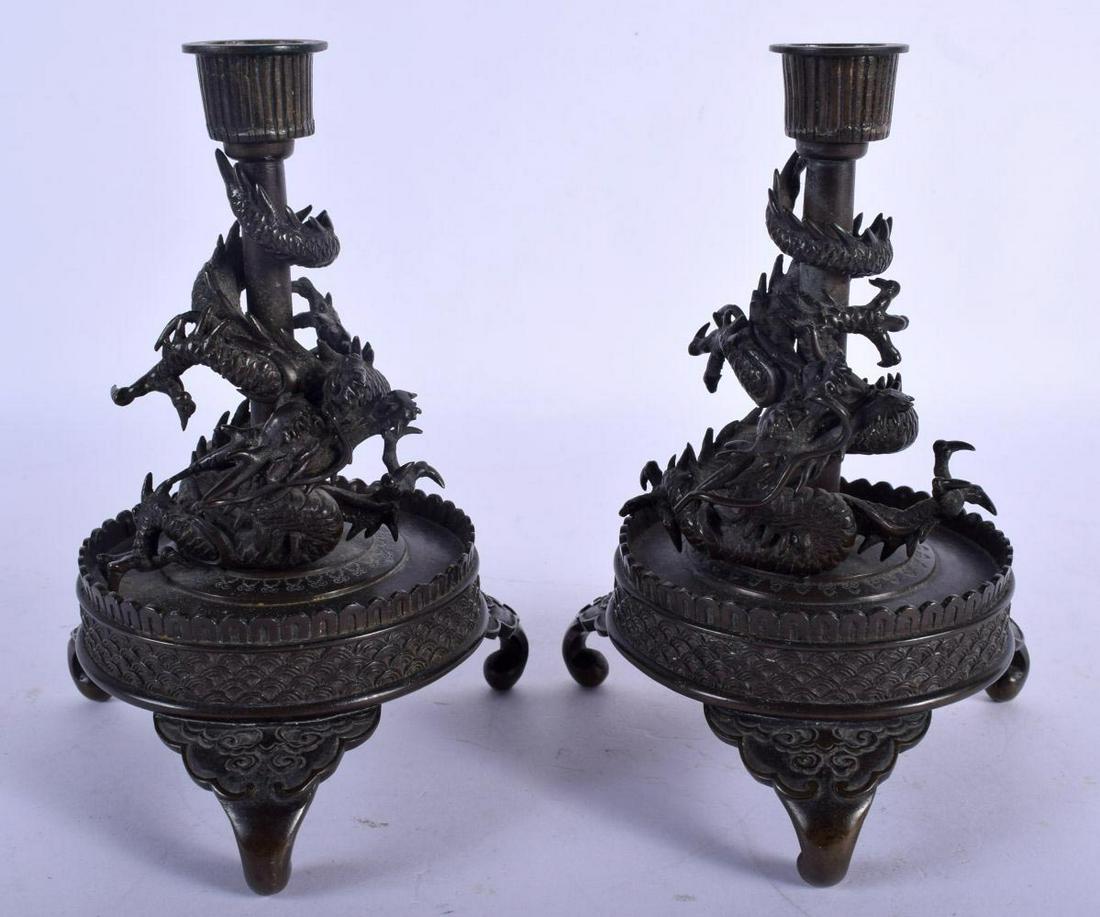 A PAIR OF 19TH CENTURY JAPANESE MEIJI PERIOD BRONZE: A PAIR OF 19TH CENTURY JAPANESE MEIJI PERIOD BRONZE CANDLESTICKS formed as a dragon upon a shaped base. 18 cm x 11 cm.