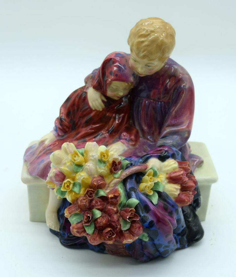 A Royal Doulton figure of two flower sellers sitting on: A Royal Doulton figure of two flower sellers sitting on a bench 20 x 18cm.