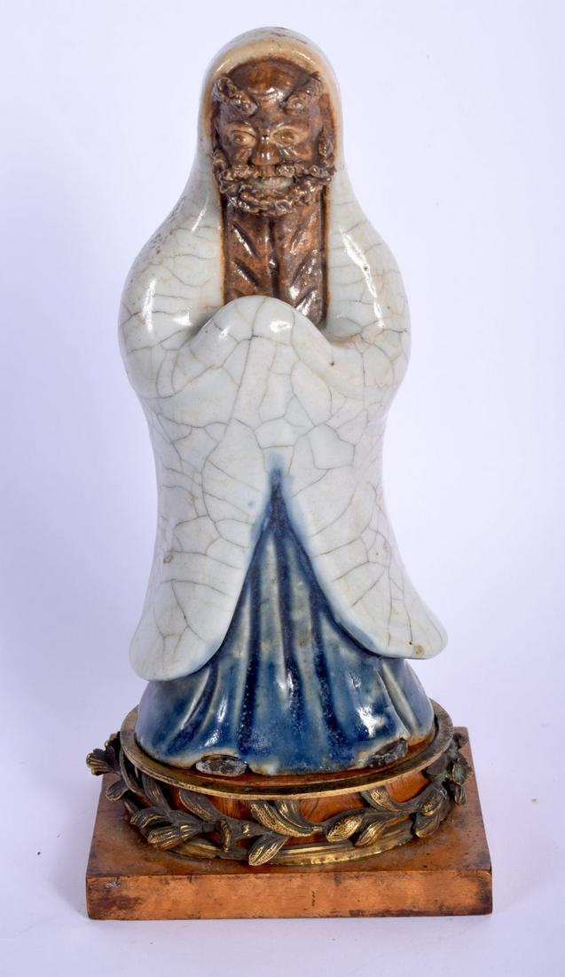 AN 18TH/19TH CENTURY CHINESE GE TYPE FIGURE OF AN: AN 18TH/19TH CENTURY CHINESE GE TYPE FIGURE OF AN IMMORTAL modelled in robes upon a later bronze mounted base. 24 cm high.
