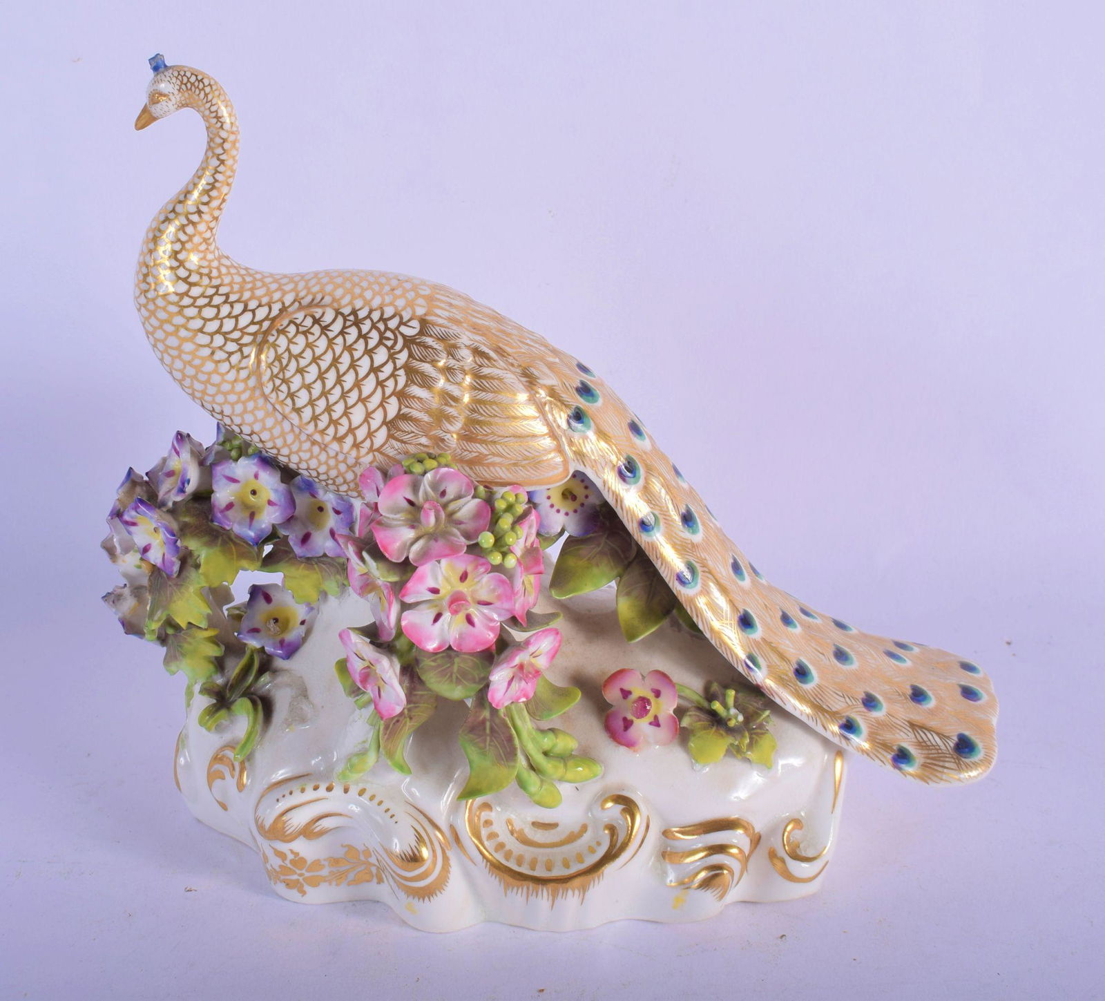 A RARE EARLY 19TH CENTURY DERBY PORCELAIN FIGURE OF A: A RARE EARLY 19TH CENTURY DERBY PORCELAIN FIGURE OF A PEACOCK modelled upon an encrusted base. 16 cm x 16 cm.