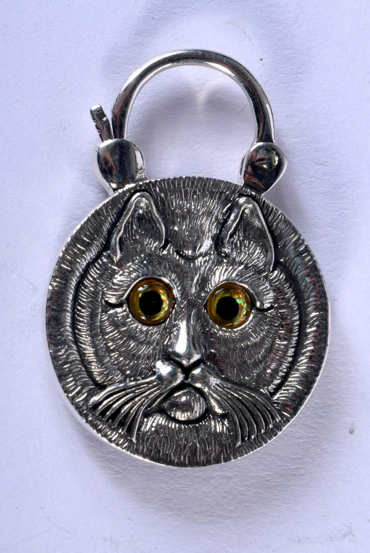 A SILVER CAT LOCKET WITH GEM SET EYES. 3.8cm x 2.6cm,: A SILVER CAT LOCKET WITH GEM SET EYES. 3.8cm x 2.6cm, weight 10.3g