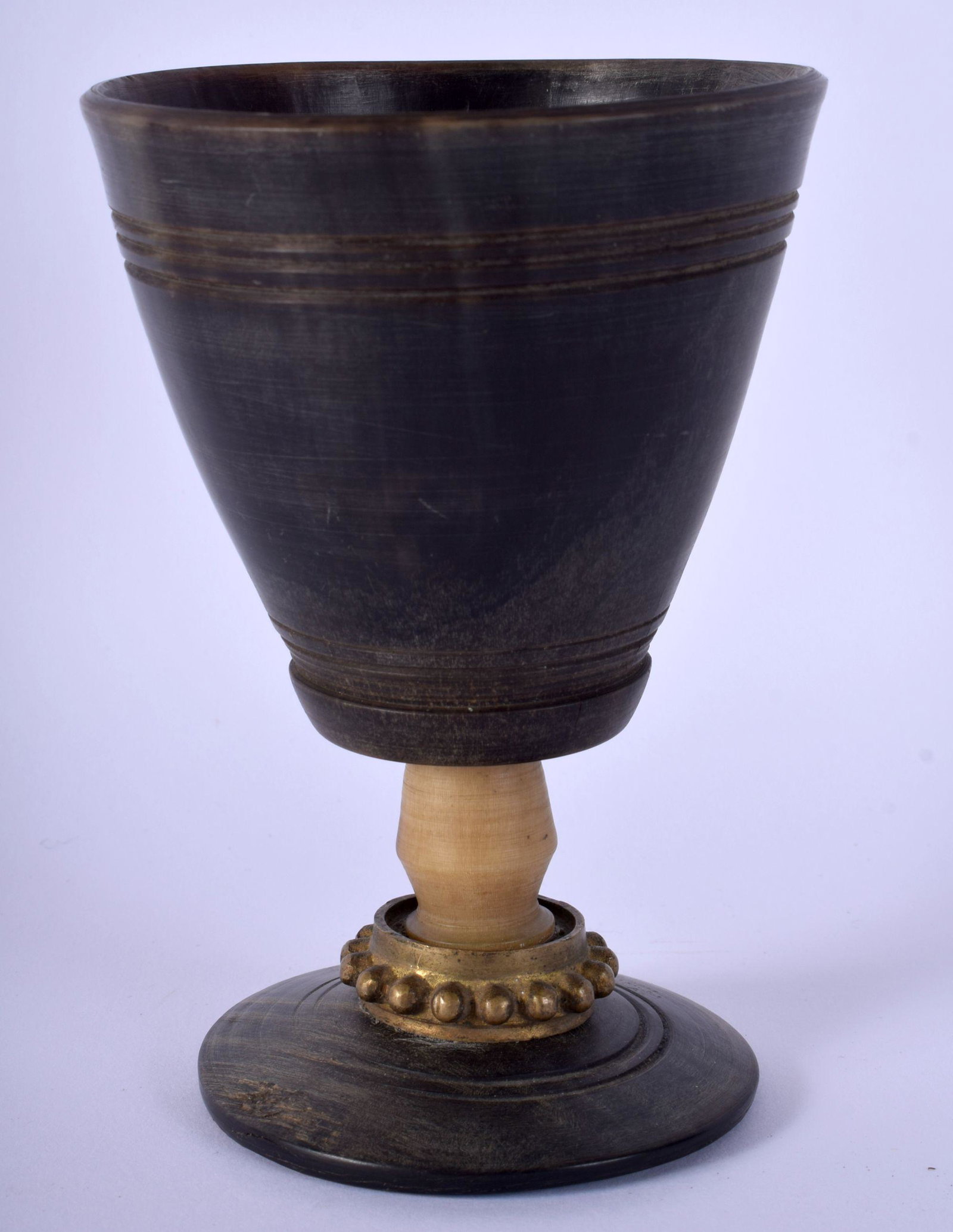AN 18TH/19TH CENTURY GERMAN CARVED RHINOCEROS HORN: AN 18TH/19TH CENTURY GERMAN CARVED RHINOCEROS HORN GOBLET BEAKER with stud work collar. 182 grams. 13 cm x 8 cm.
