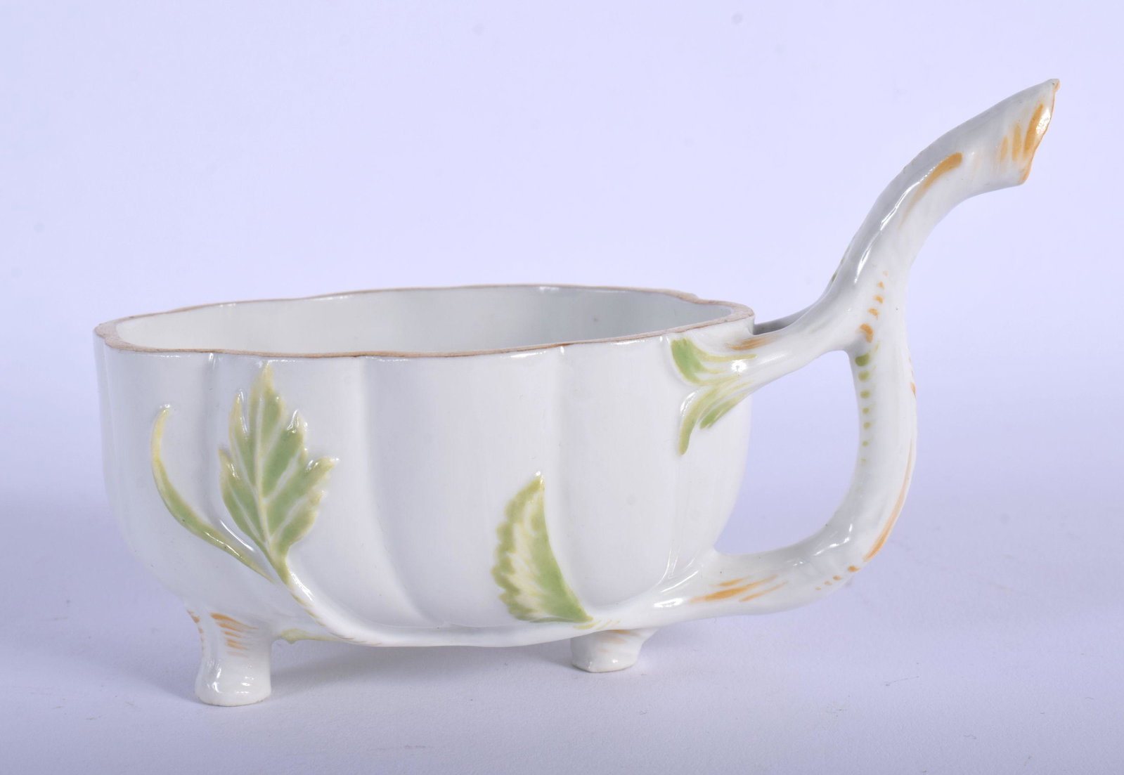 FURSTENBERG RARE LEAF-SHAPED CREAMBOAT OF FLUTED OVAL: FURSTENBERG RARE LEAF-SHAPED CREAMBOAT OF FLUTED OVAL SHAPE, THE INTERIORS PAINTED WITH COLOURFUL FLOWER SPRAYS, THE TWIG HANDLES EXTENDING INTO MOULDED LEAVES AND THREE FEET, F MARK IN BLUE. 7cm high