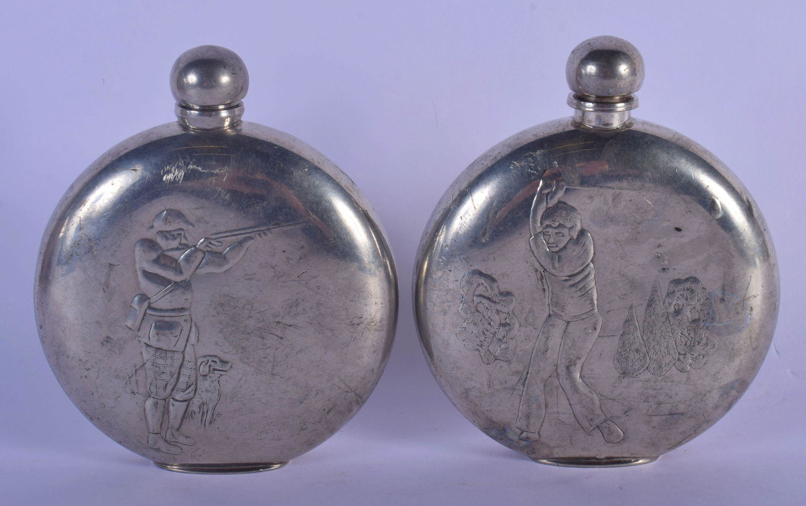 A RARE PAIR OF VINTAGE SILVER PLATED HUNTING HIP FLASKS: A RARE PAIR OF VINTAGE SILVER PLATED HUNTING HIP FLASKS depicting a hunter and golfer. 12 cm x 9 cm.