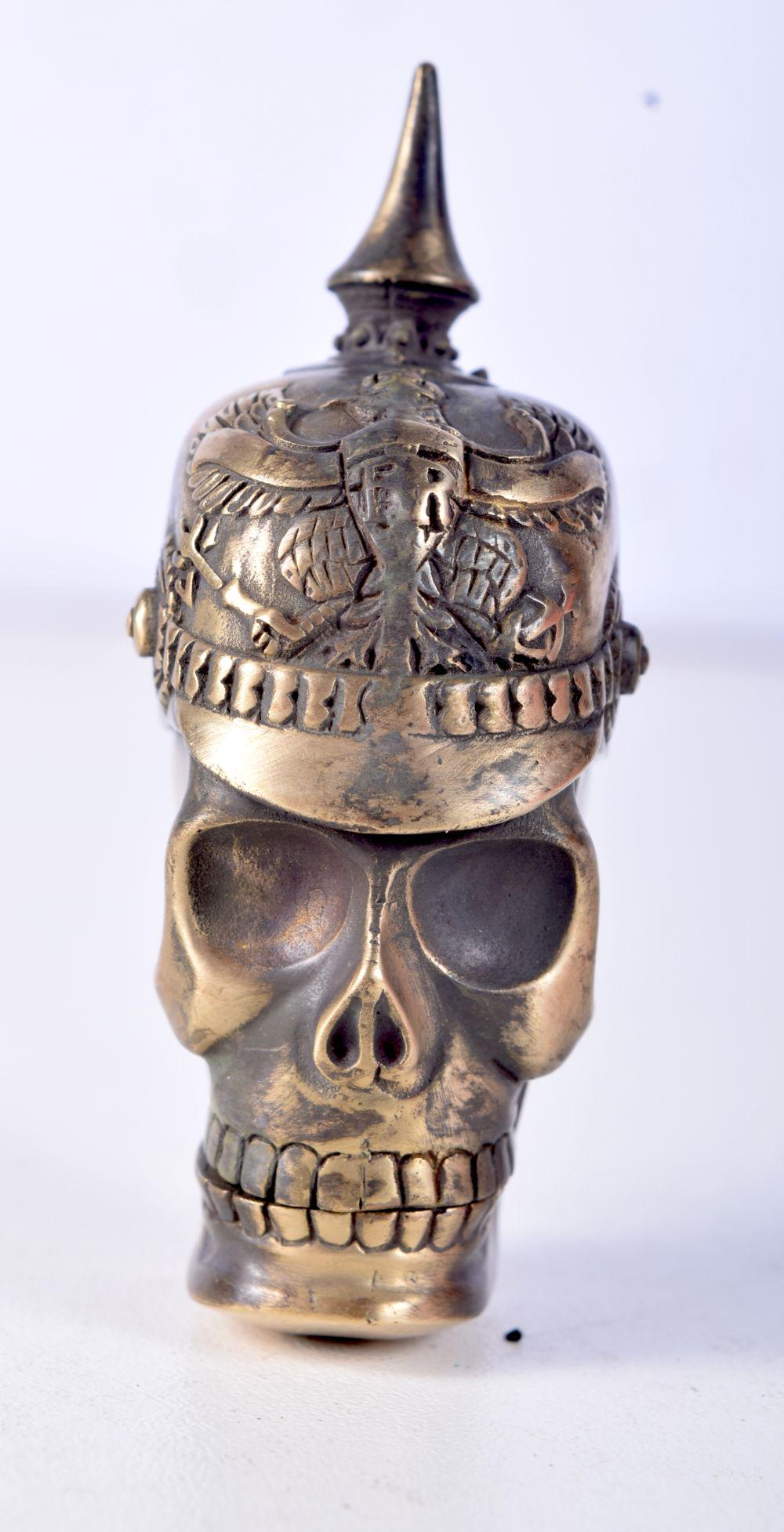 A BRASS VESTA CASE IN THE FORM OF A SKULL WEARING A PICKELHAUBE.  6.5cm x 3.7cm, weight 47g (1 of 4)