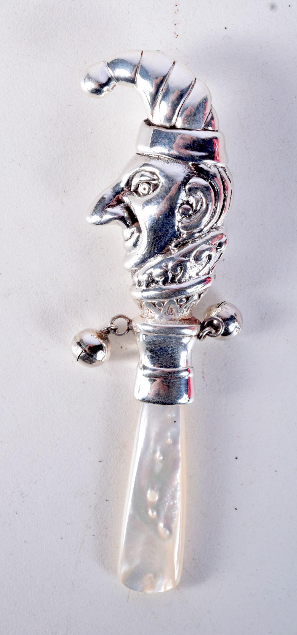 A SILVER BABIES RATTLE IN THE FORM OF MR PUNCH. Stamped Sterling, 9.5cm x 2.5cm x 1.5cm, weight 12.: A SILVER BABIES RATTLE IN THE FORM OF MR PUNCH. Stamped Sterling, 9.5cm x 2.5cm x 1.5cm, weight 12.8g