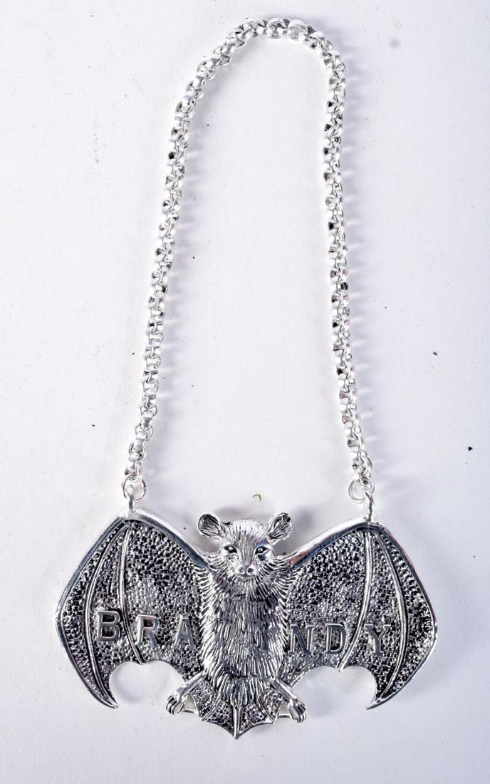 A CONTINENTAL SILVER DECANTER LABEL IN THE FORM OF A BAT INSCRIBED BRANDY.  4.6cm x 7.6cm, weight 42 (1 of 2)