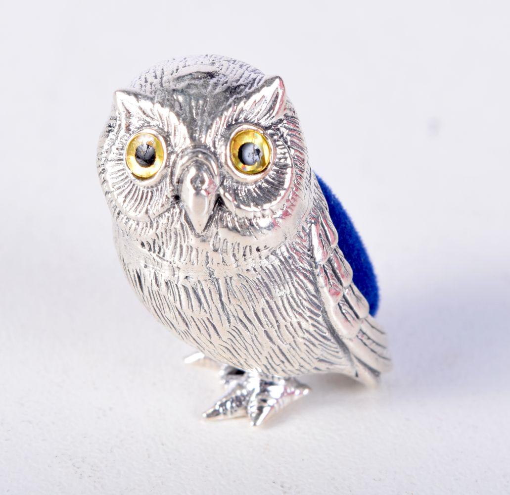 A MINIATURE SILVER PIN CUSHION IN THE FORM OF AN OWL.  Stamped Sterling, 2.4cm x 1.4cm, weight 12g (1 of 3)