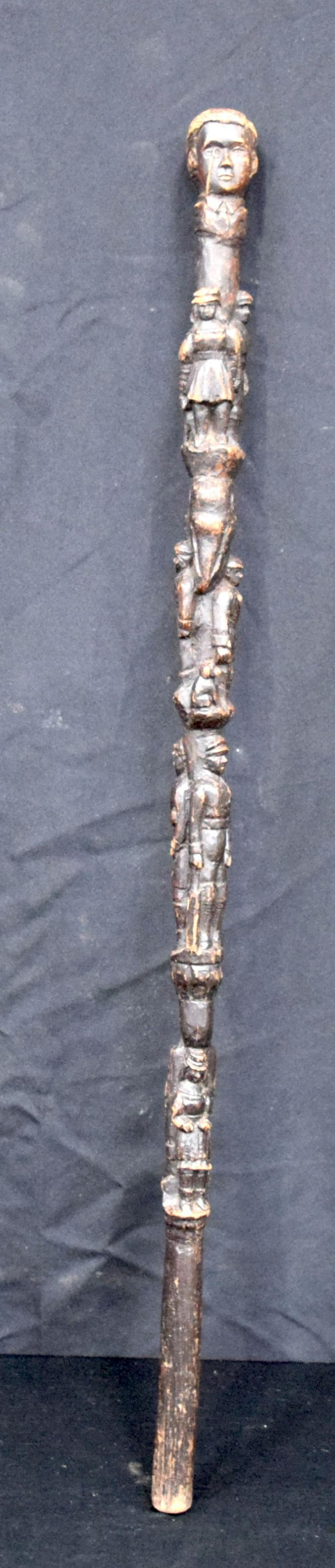 An early wooden walking cane carved with figures and animals including a cricketer 89cm.: An early wooden walking cane carved with figures and animals including a cricketer 89cm.