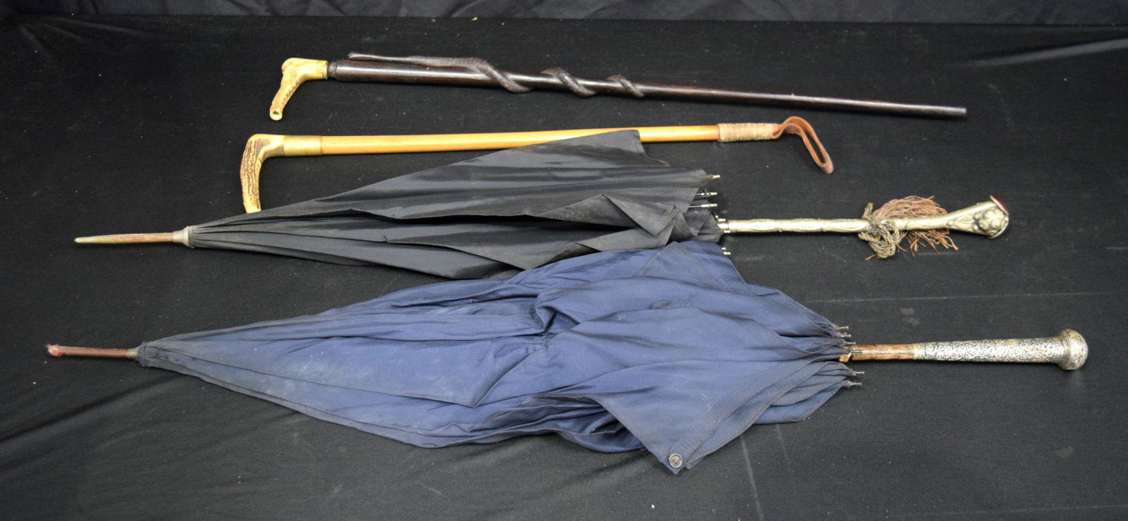 A collection of carved wood walking canes, embossed metal handled parasols and a crop longest 90 cm (1 of 11)