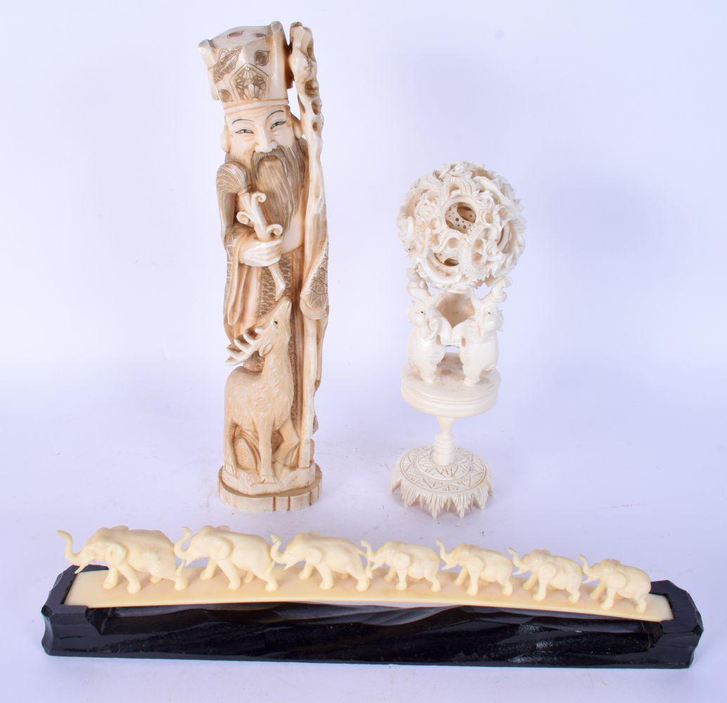 A 19TH CENTURY JAPANESE MEIJI PERIOD CARVED IVORY OKIMONO together with a puzzle ball C1900 and an e: A 19TH CENTURY JAPANESE MEIJI PERIOD CARVED IVORY OKIMONO together with a puzzle ball C1900 and an elephant group. Largest 26 cm high. (3)