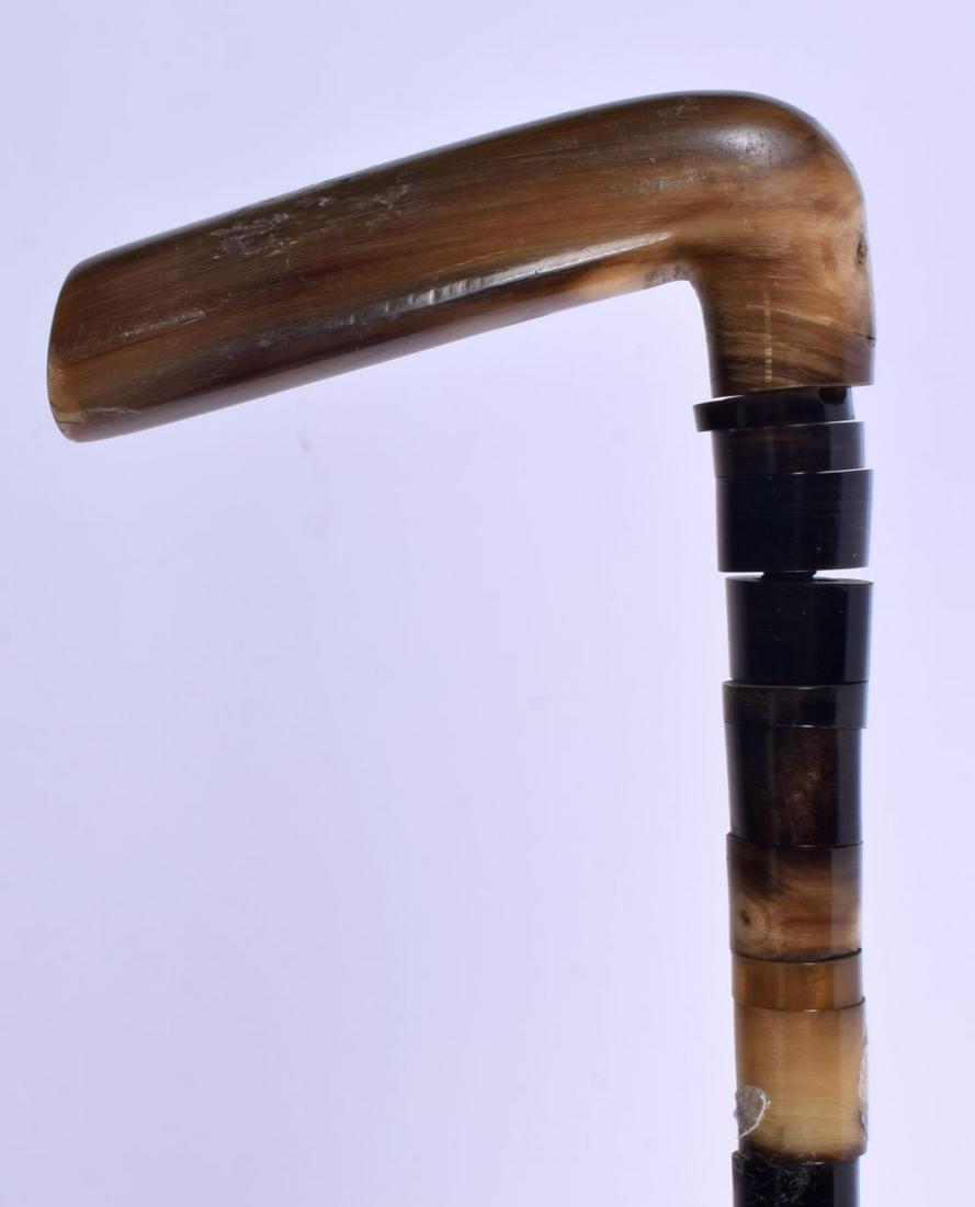 A 19TH CENTURY MIDDLE EASTERN CARVED RHINOCEROS HORN HANDLED WALKING CANE with horn shaft. 90 cm lon: A 19TH CENTURY MIDDLE EASTERN CARVED RHINOCEROS HORN HANDLED WALKING CANE with horn shaft. 90 cm long.
