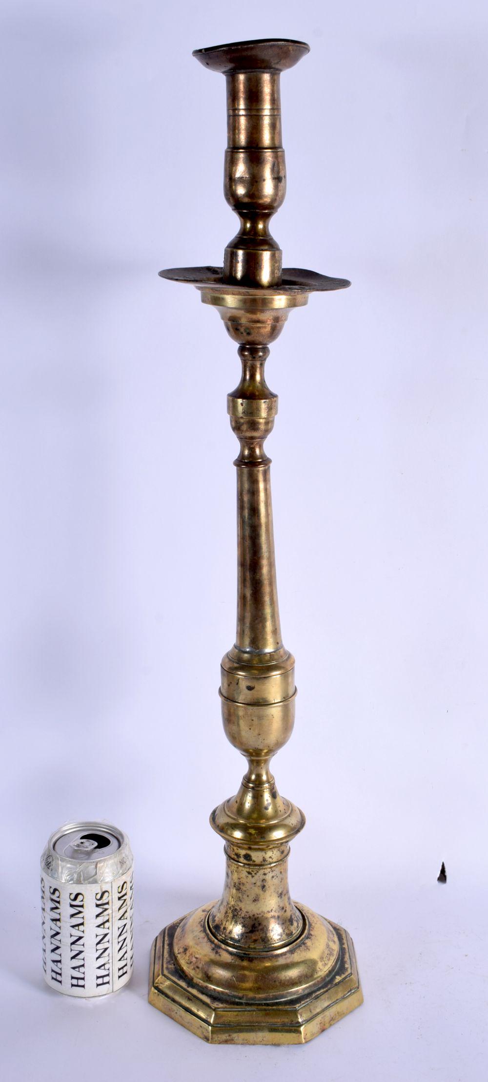 A LARGE 18TH CENTURY CONTINENTAL BRASS ALTAR TYPE CANDLESTICK. 64 cm high. (1 of 4)