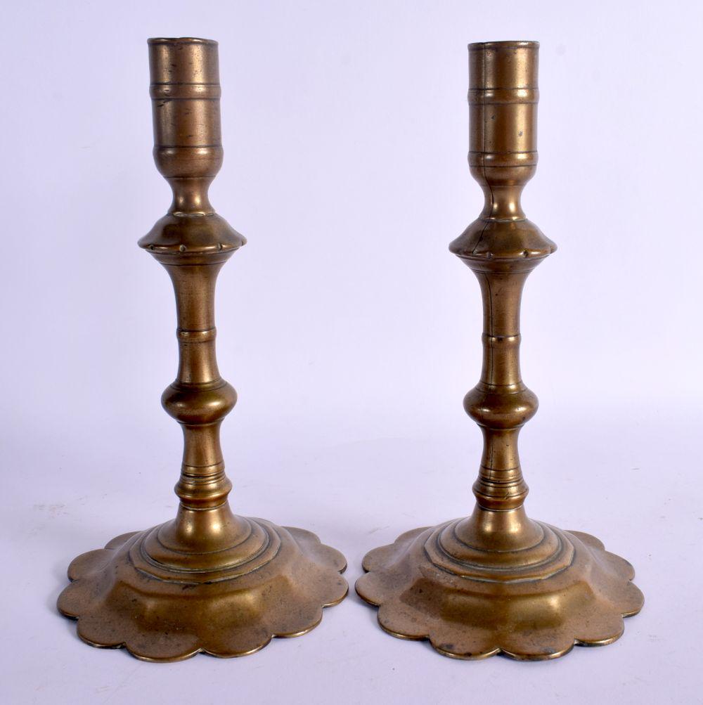 A PAIR OF 18TH CENTURY EUROPEAN BRASS SEAMED CANDLESTICKS upon petal bases. 21 cm high. (1 of 3)
