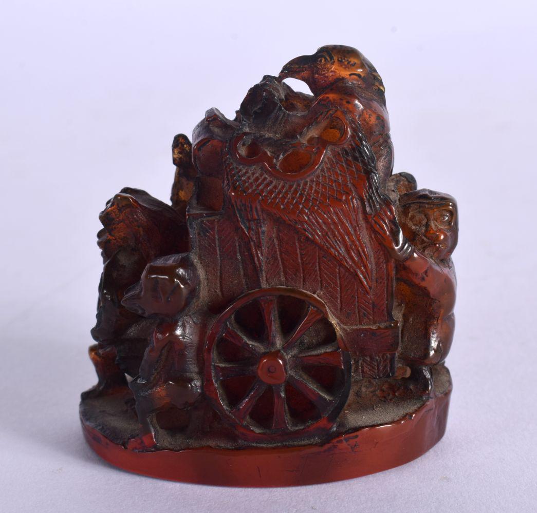 A RARE 19TH CENTURY JAPANESE MEIJI PERIOD CARVED AMBER NETSUKE modelled with figures pulling a cart. (1 of 5)