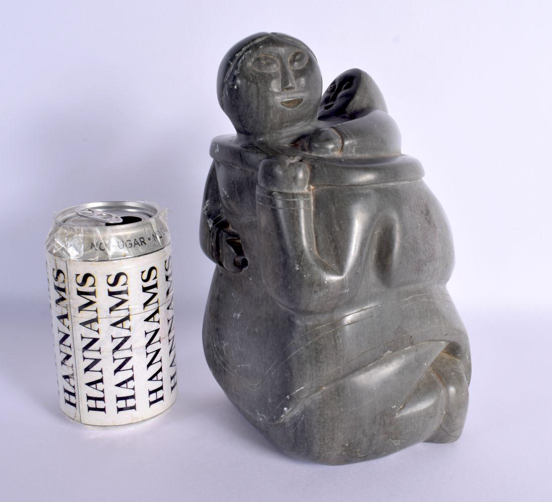 A LARGE NORTH AMERICAN INUIT CARVED STONE FIGURE OF A FEMALE modelled with a baby upon her back. 22 (1 of 4)