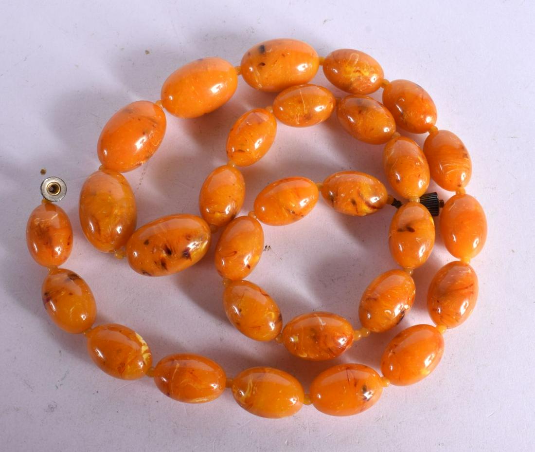 AN AMBER COLOURED BAKELITE NECKLACE. Length 85cm, bead size 16mm, weight 96g: AN AMBER COLOURED BAKELITE NECKLACE. Length 85cm, bead size 16mm, weight 96g