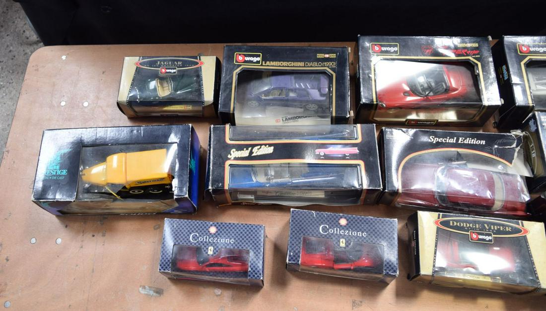 A collection of boxed Burago model cars together with other models (12) in two boxes. (1 of 6)