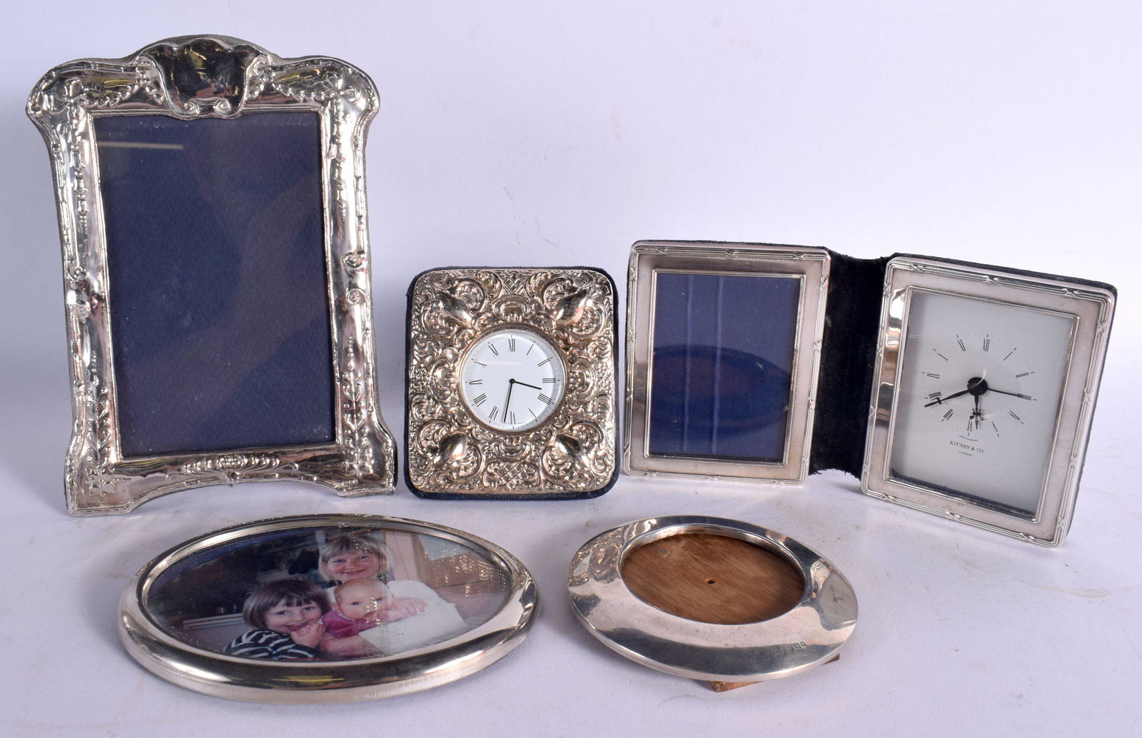 THREE SILVER MOUNTED PHOTOGRAPH FRAMES together with two silver clocks. London 1921, 1970 & 1995. 67 (1 of 8)