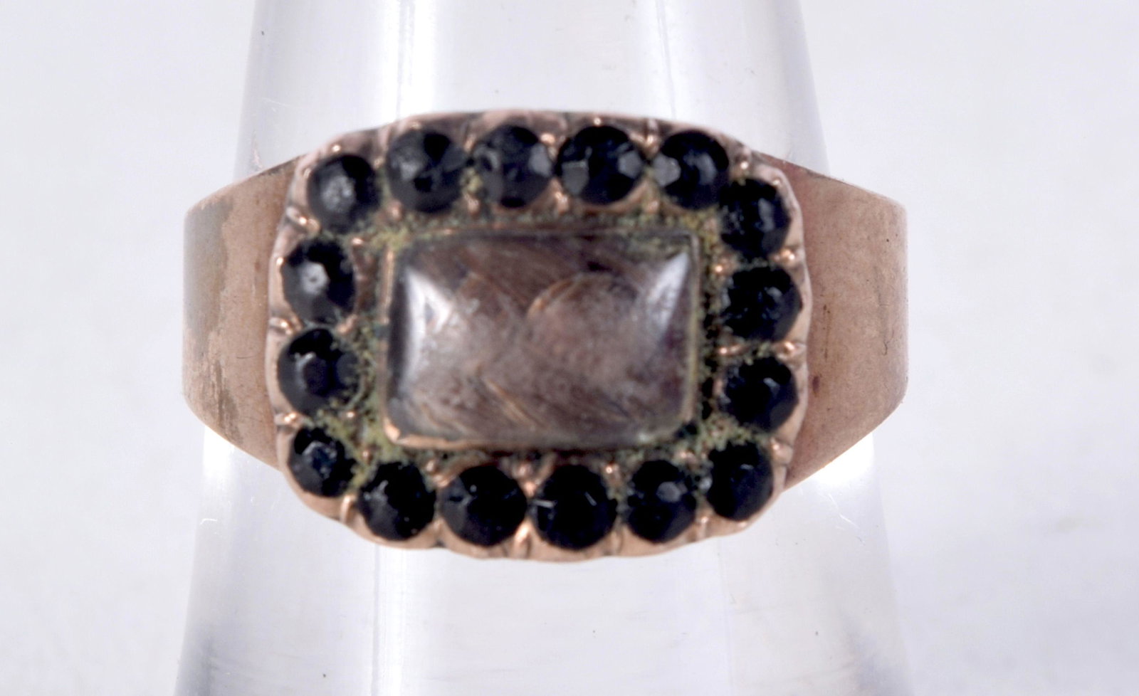 AN ANTIQUE YELLOW METAL GARNET AND HAIR MOURNING RING. N. 3.2 grams.: AN ANTIQUE YELLOW METAL GARNET AND HAIR MOURNING RING. N. 3.2 grams.