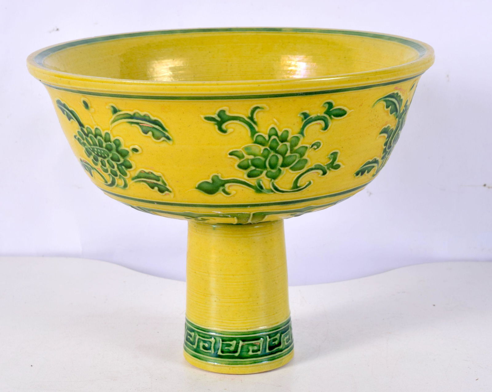 A Chinese porcelain Imperial yellow stem cup decorated in relief with foliage 14 x 18 cm. (1 of 4)