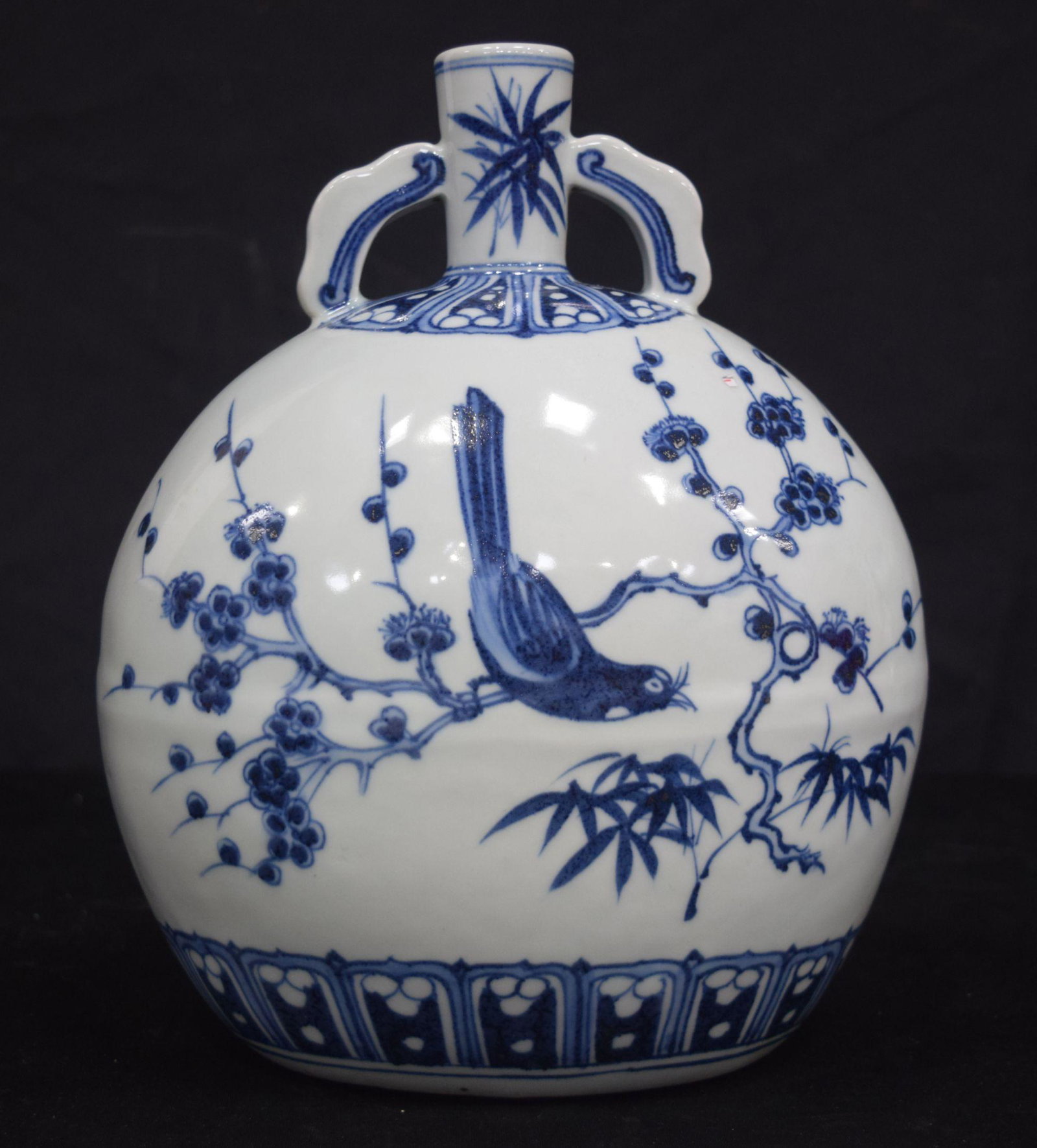 A Chinese porcelain blue and white twin handled flask decorated with birds in foliage 26cm.: A Chinese porcelain blue and white twin handled flask decorated with birds in foliage 26cm.