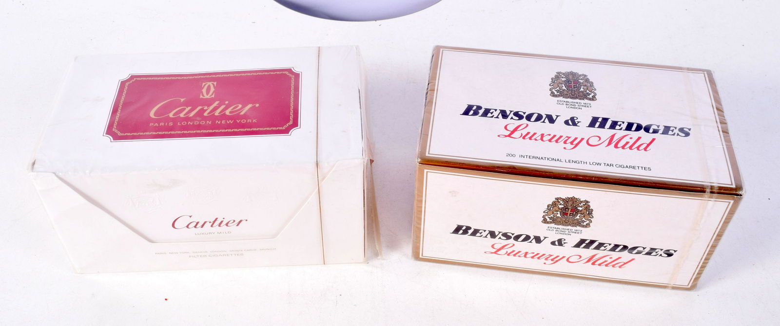 A pack of unopened Cartier cigarettes together with a pack of Benson and Hedges (2).: A pack of unopened Cartier cigarettes together with a pack of Benson and Hedges (2).