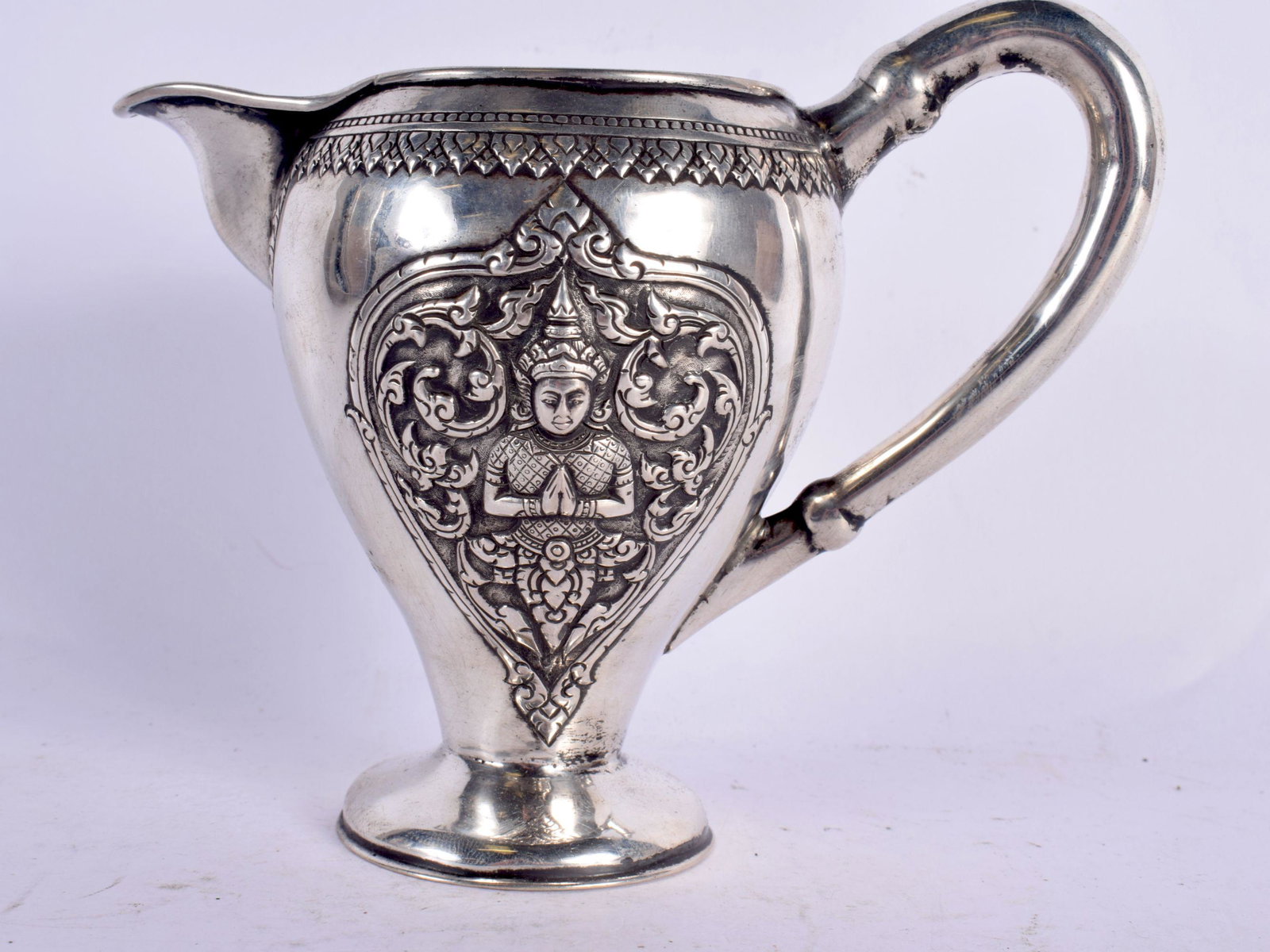 A 19TH CENTURY SOUTH EAST ASIAN CHINESE TIBETAN SILVER JUG decorated with buddhistic figures. 153 gr: A 19TH CENTURY SOUTH EAST ASIAN CHINESE TIBETAN SILVER JUG decorated with buddhistic figures. 153 grams. 15 cm x 12 cm.