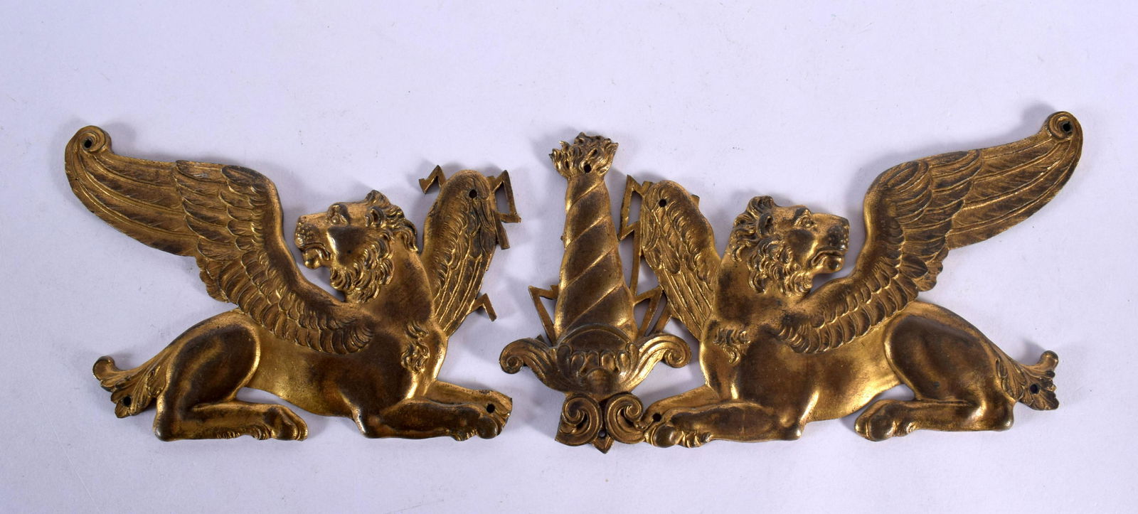 A FINE PAIR OF GEORGE III BRONZE GRIFFIN LION PLAQUES modelled recumbant. 15 cm x 8 cm. (1 of 2)