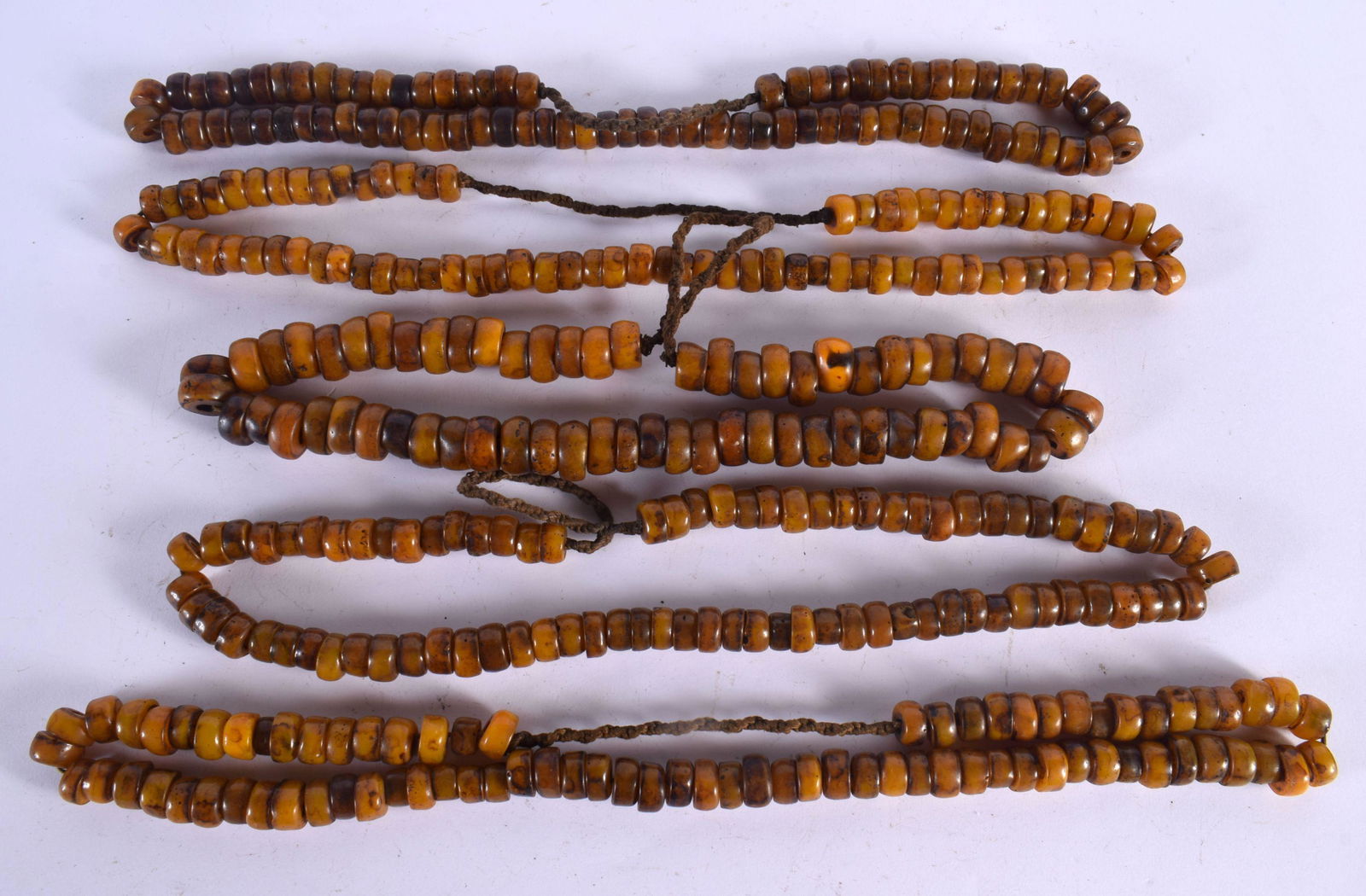 FIVE MIDDLE EASTERN CARVED AMBER PRAYER BEAD NECKLACES. 617 grams. 64 cm long. (5) (1 of 3)