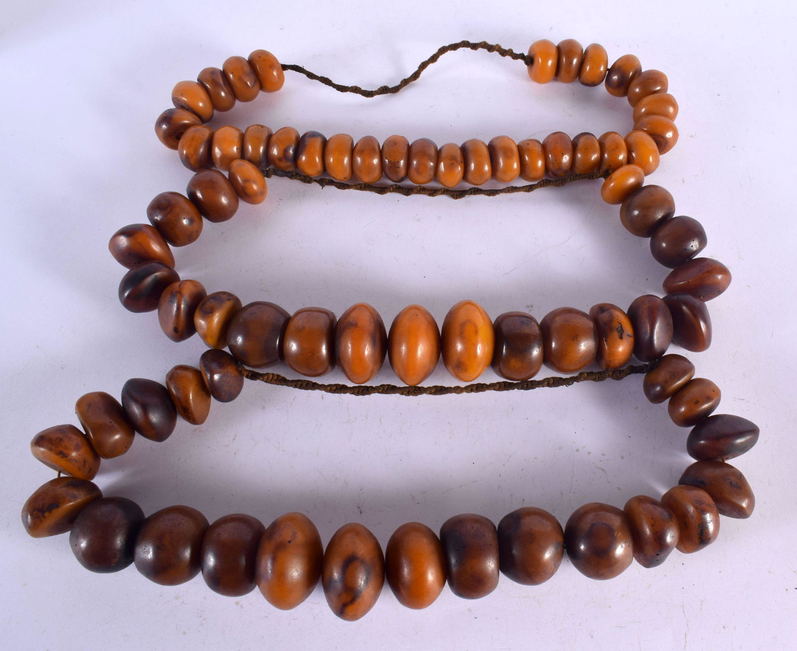 THREE LARGE MIDDLE EASTERN CARVED AMBER BOULDER NECKLACES. 1460 grams. 68 cm long. (3) (1 of 2)